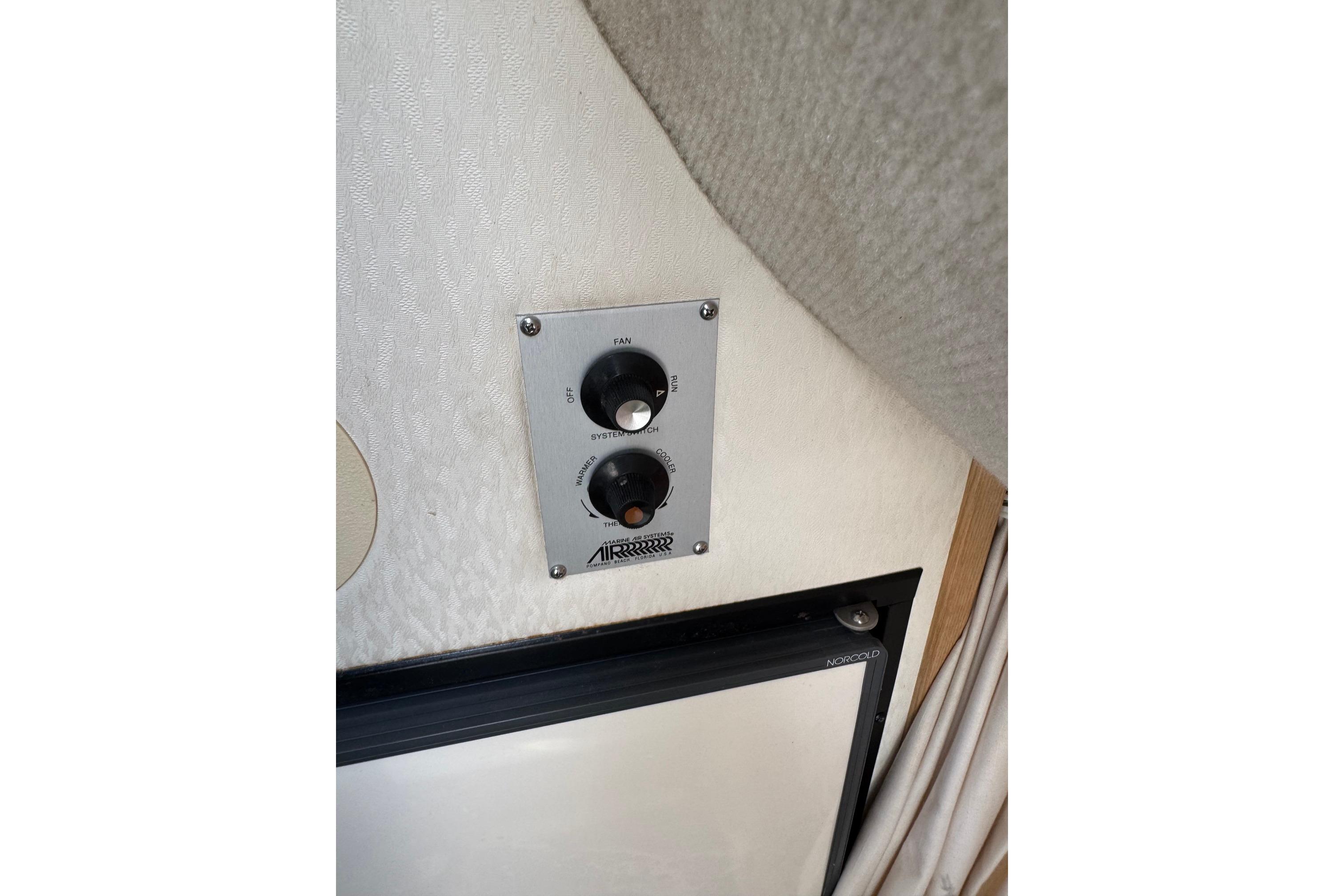 Control panel inside 2000 Maxum 2400 SCR boat, featuring fan and system switches.