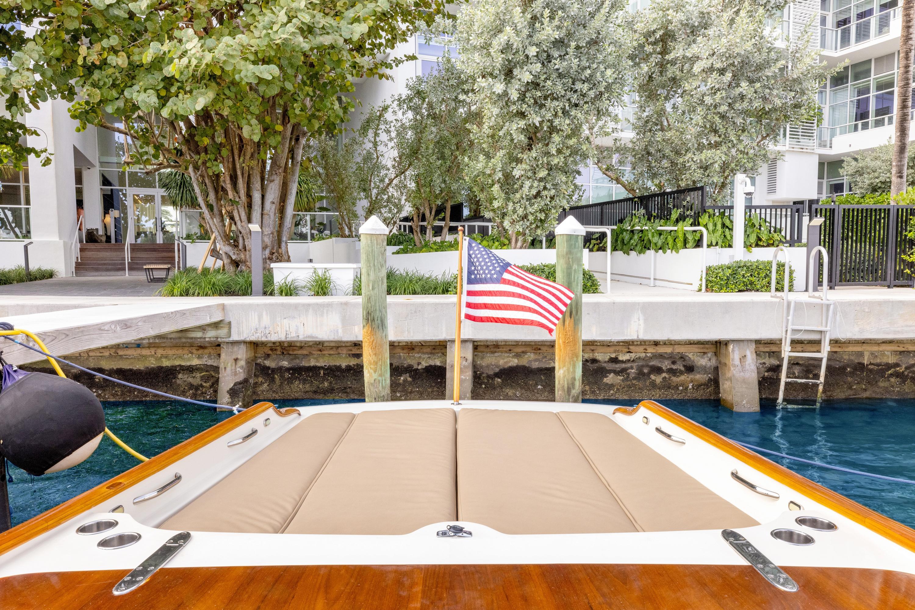 2009 Hinckley Runabout 38 docked, featuring American flag and waterfront view.