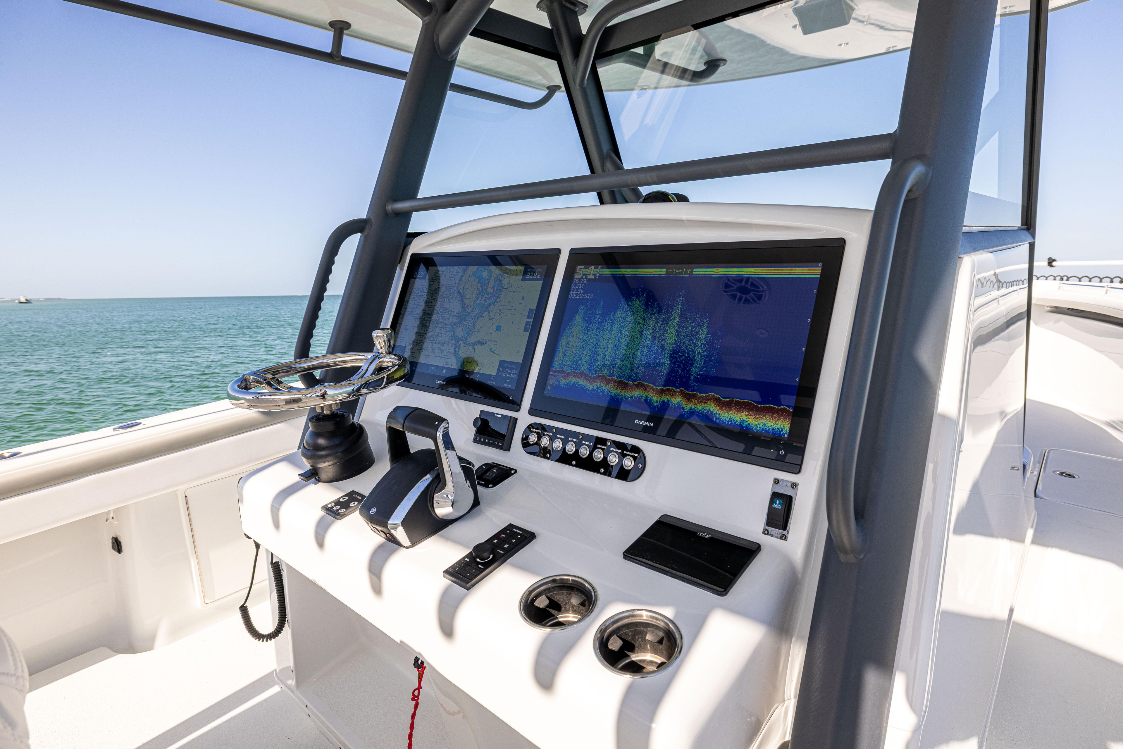 2023 Yellowfin 39 Offshore boat dashboard with dual screens and controls, ocean view.