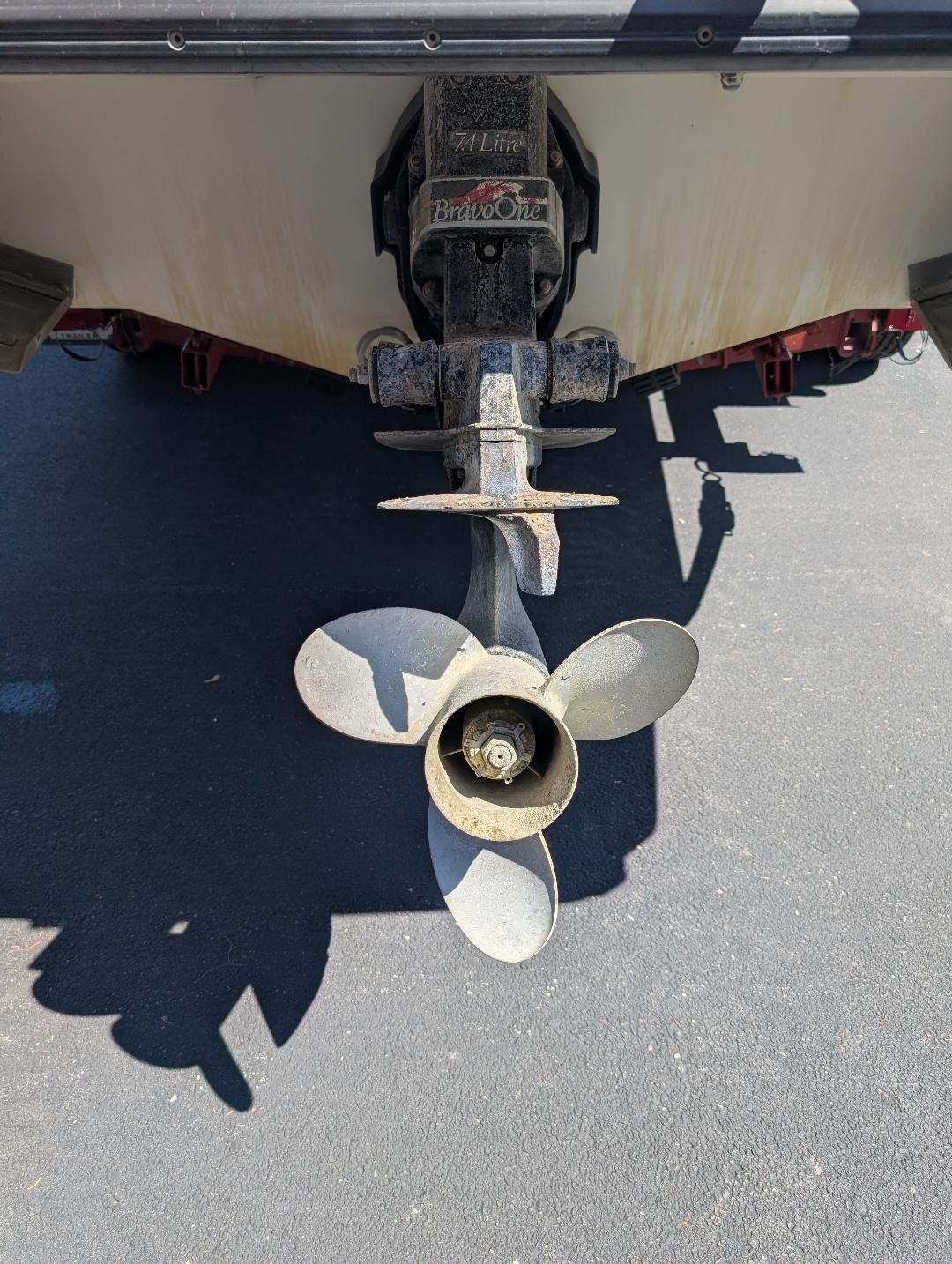 A boat hull with a propeller and drive system on a trailer.