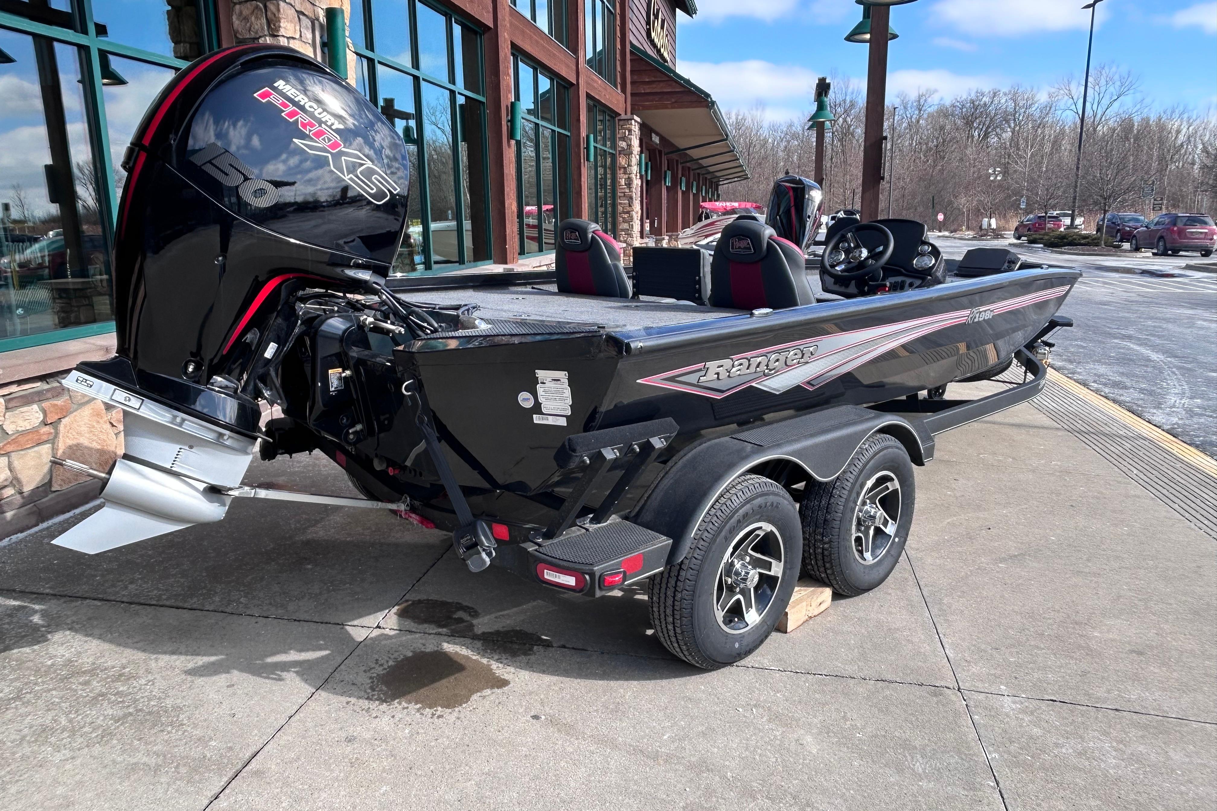 2025 Ranger RT198P boat with Mercury engine, parked outside a building on a sunny day.