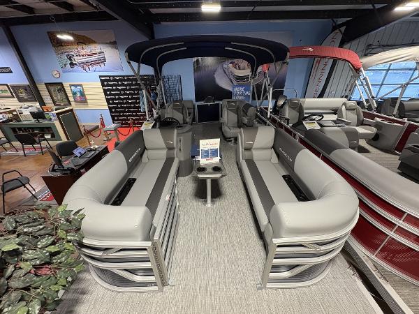 2025 Bennington 20 pontoon boat with gray seating, displayed in a showroom.