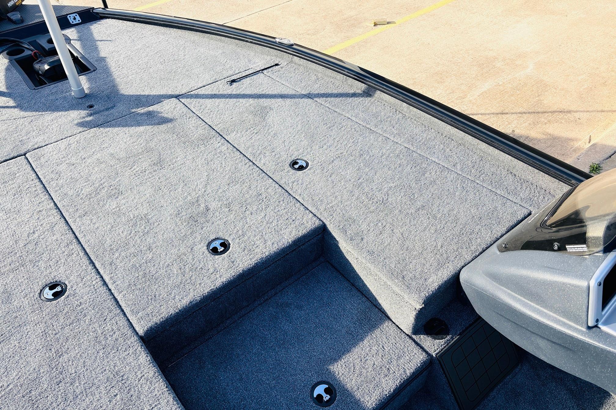 2025 Tracker Savage 215 boat deck with gray carpet and storage compartments.