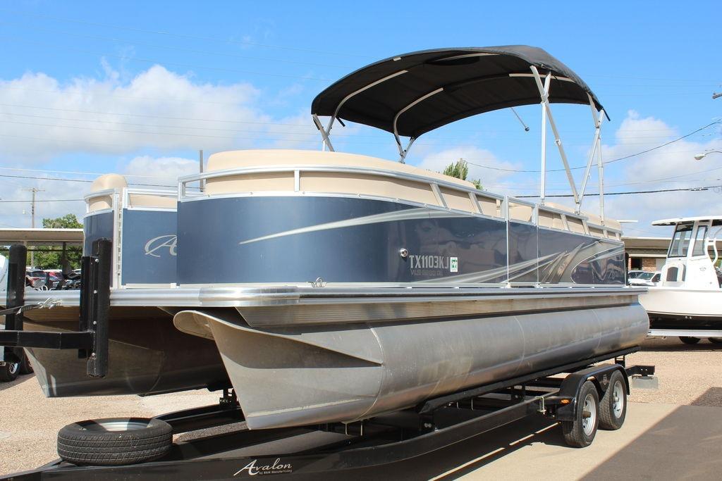 2021 Avalon VLS Quad Lounge 22 FT pontoon boat on trailer, under sunny sky.