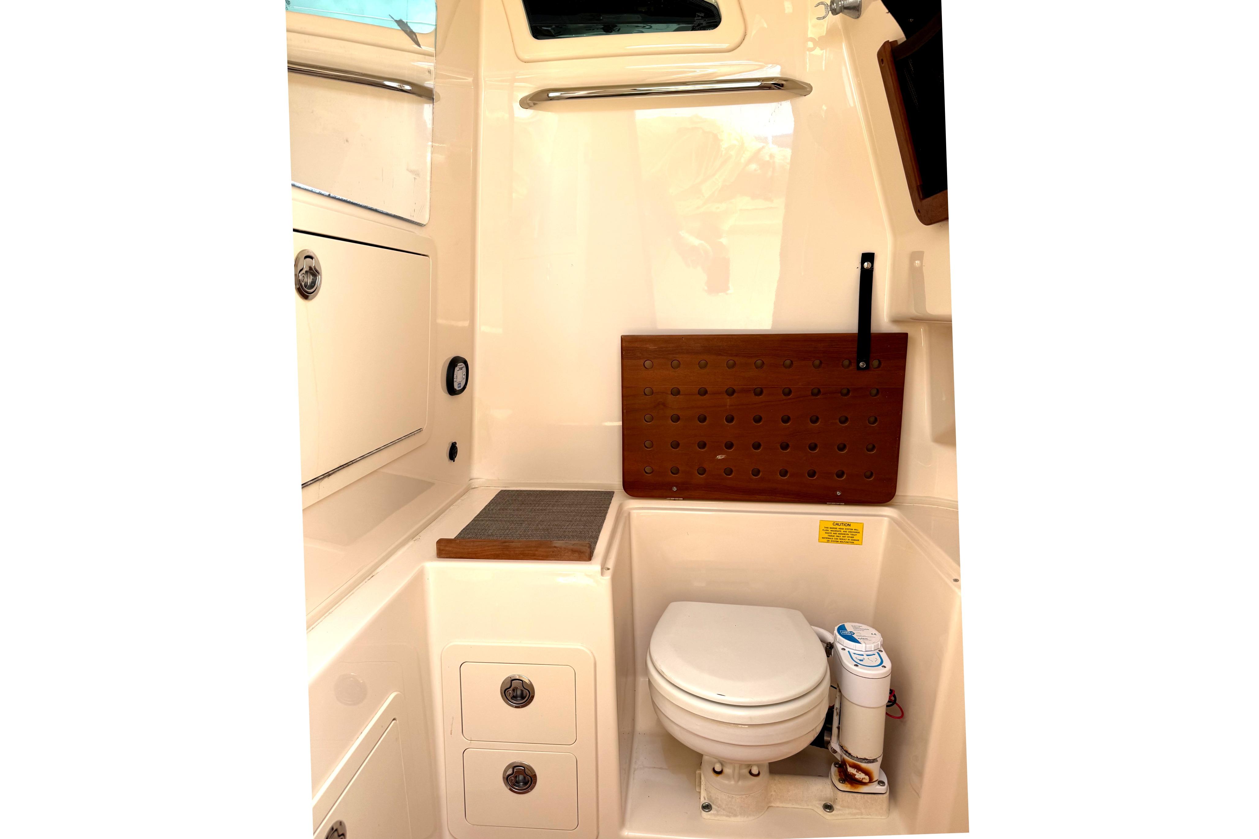 2018 Grady-White Canyon 306 boat interior with compact marine toilet and storage.