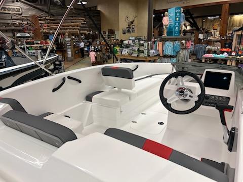 2025 Tahoe T16 boat interior with modern steering and seating, displayed in a showroom.