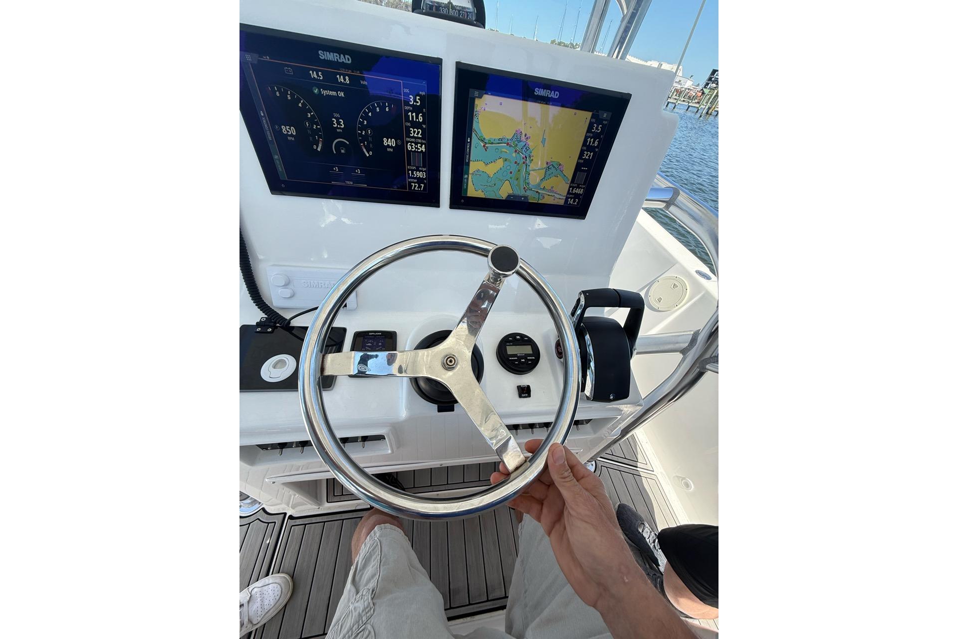 Steering console of 2021 Custom Infusion 34 CC boat with navigation displays.