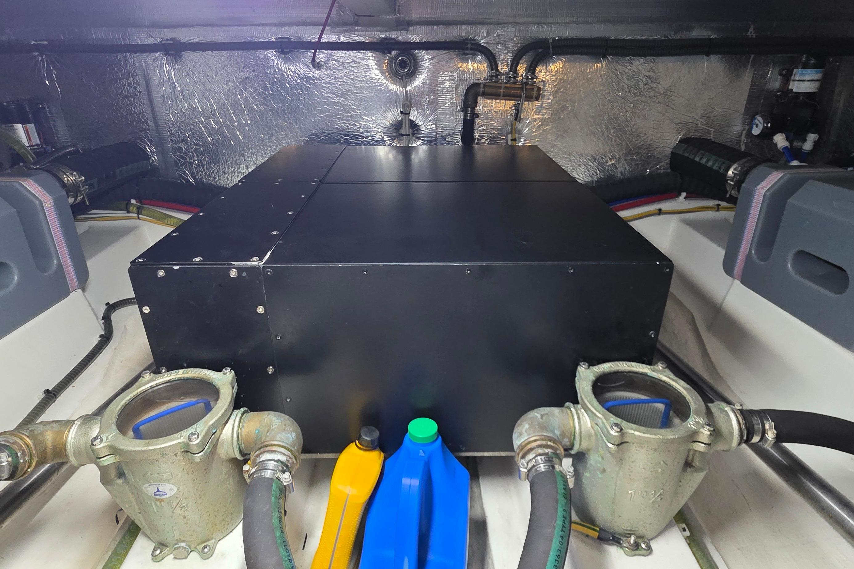 Engine room of 2023 Greenline 40 yacht with mechanical components and fluid containers.