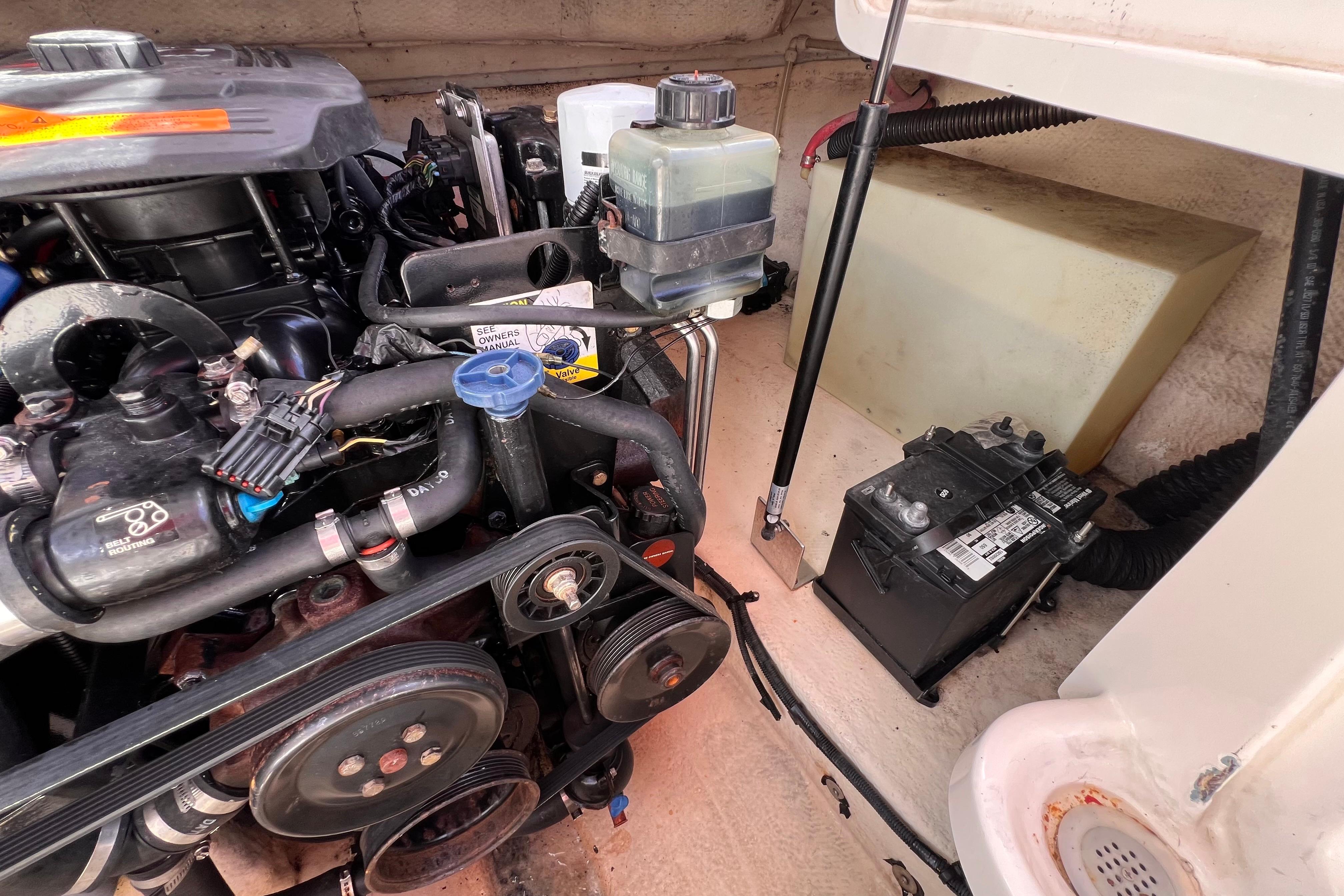 Engine compartment of a 2002 Chaparral 232 Sunesta boat, showing engine and battery.