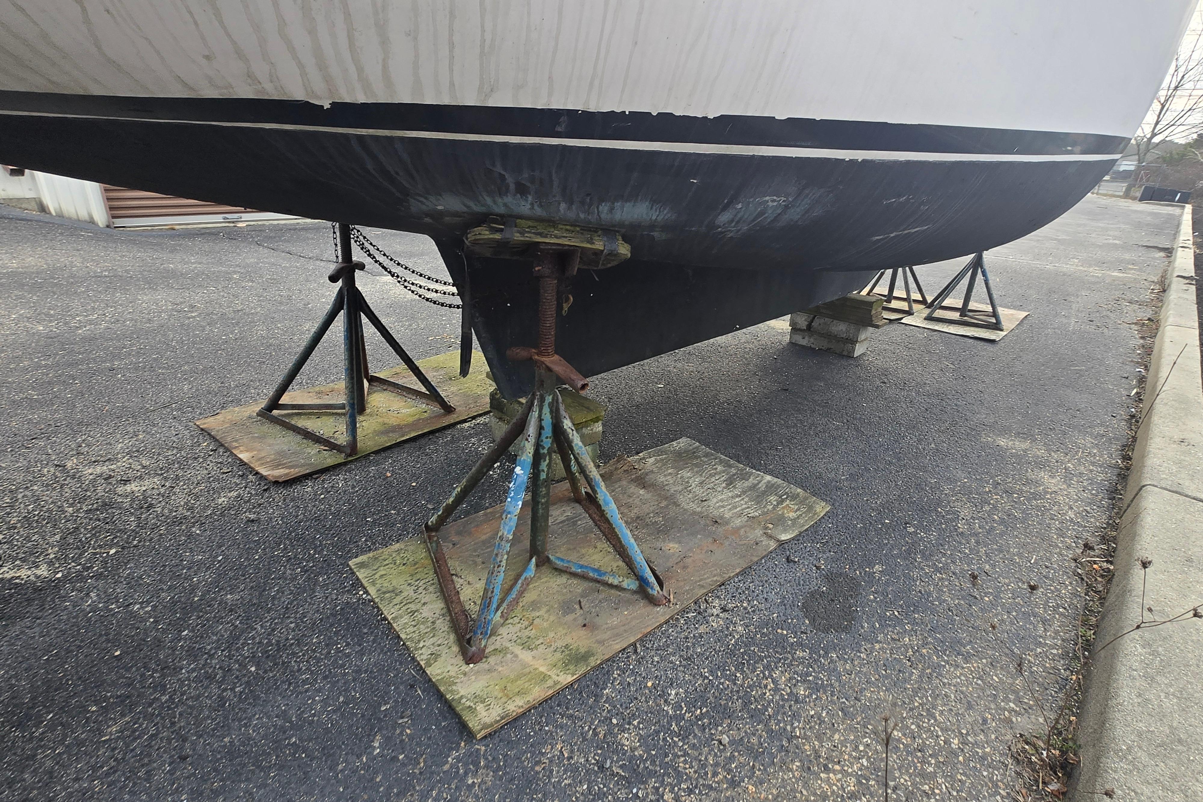 1986 Sovereign 24 sailboat hull supported by stands on pavement.