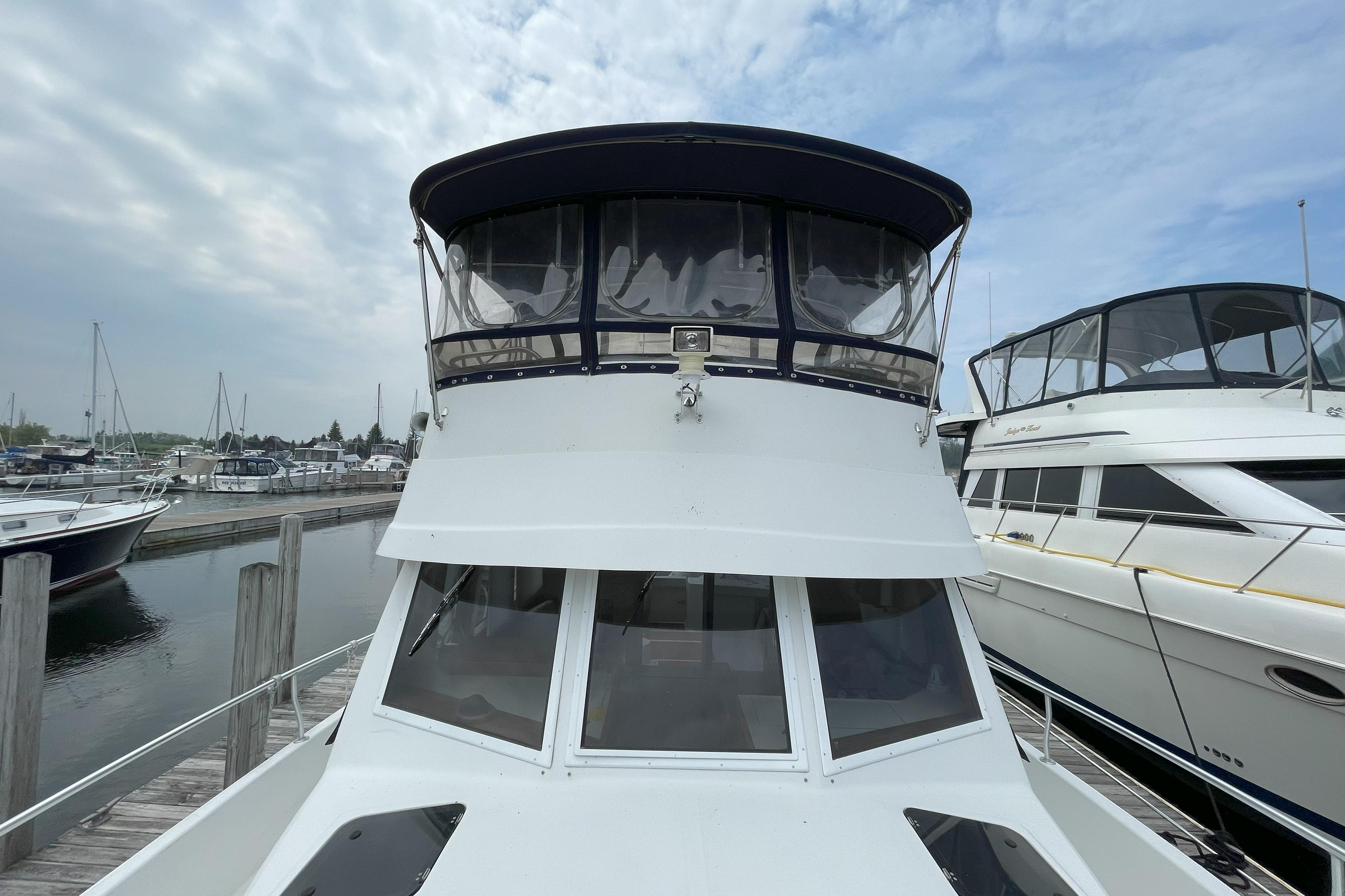 2000 Mainship 390 Trawler docked at marina, showcasing front view and upper deck.