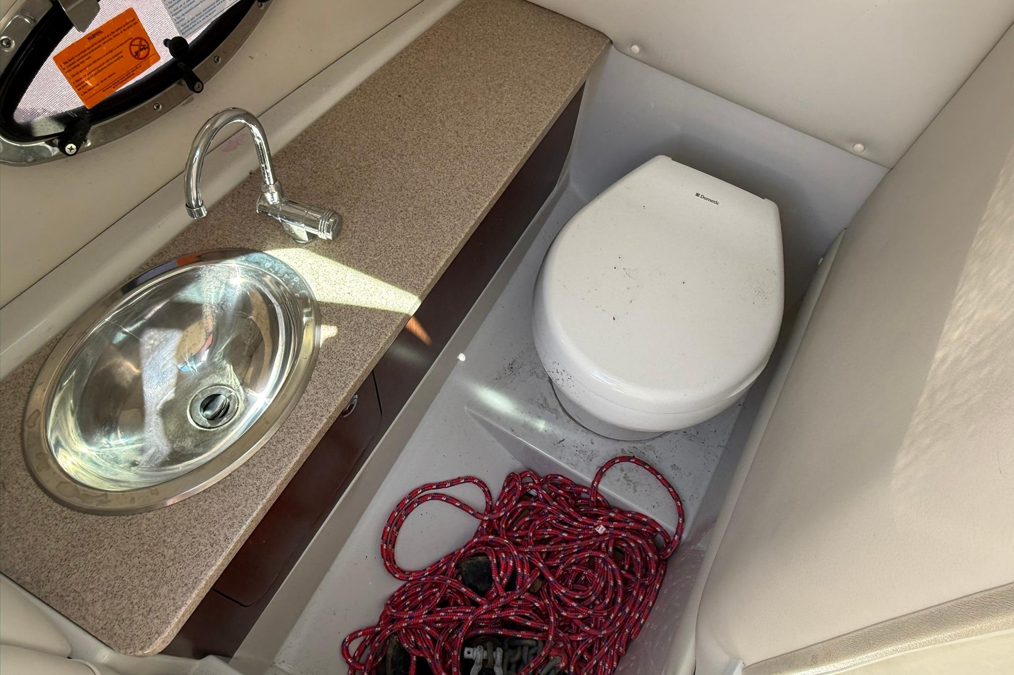 2016 Crownline 255 SS boat bathroom with sink, toilet, and red rope.