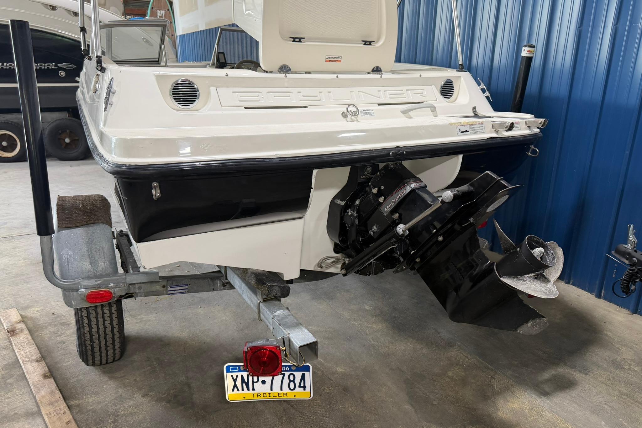 2012 Bayliner 175 Bowrider on trailer, rear view showing outboard motor and license plate.