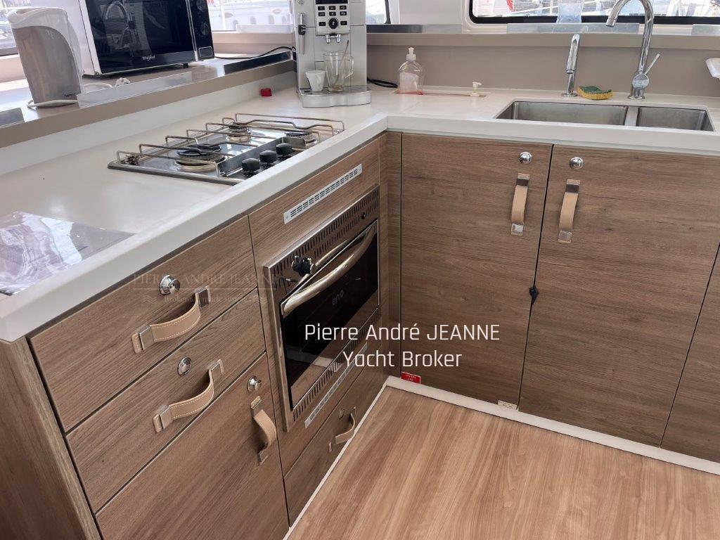 Modern yacht kitchen with wooden cabinets, stove, oven, and double sink. Bali 4.4, 2023 model.