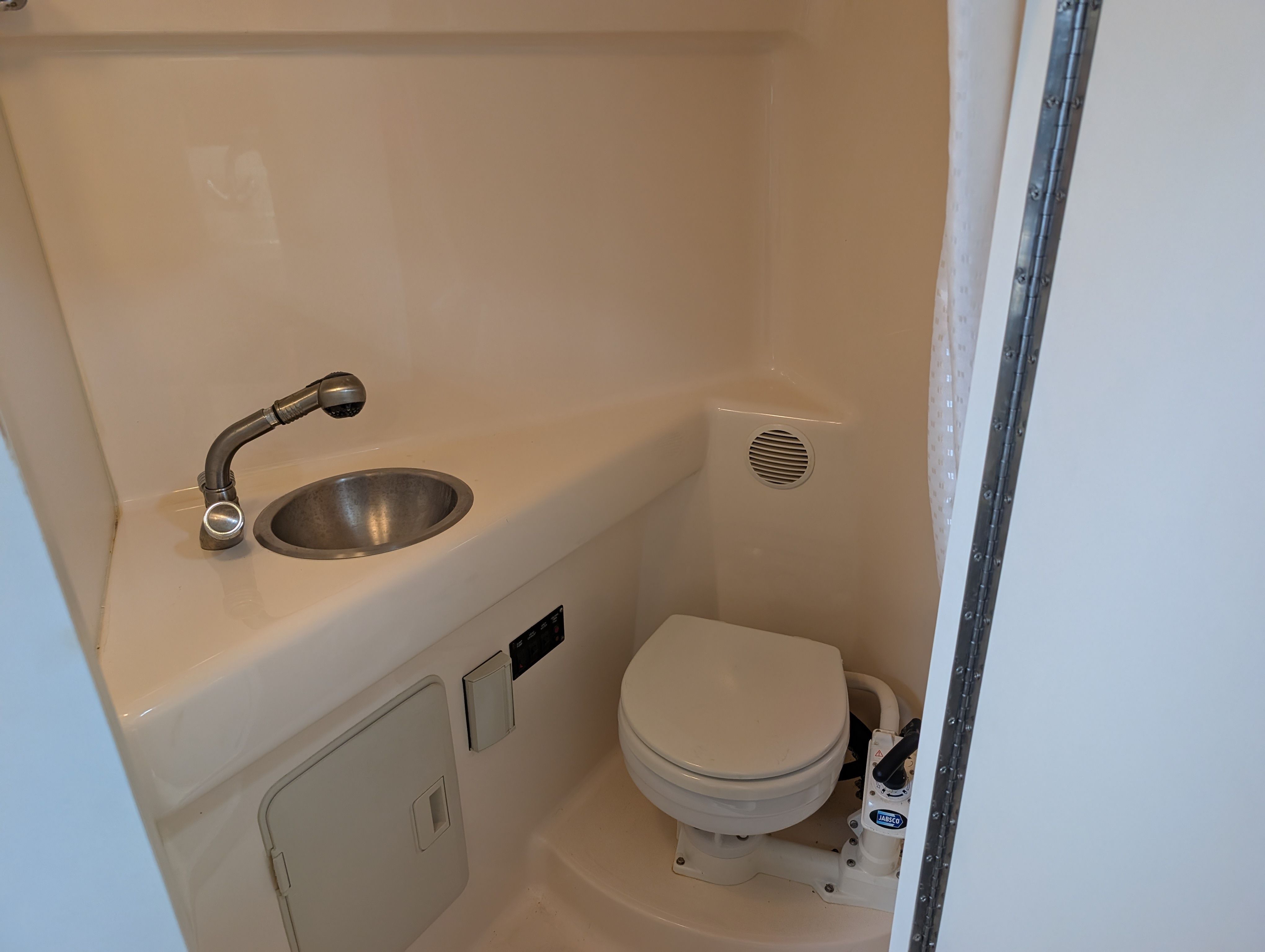 Interior of a 2006 Glastron GS boat toilet with sink.