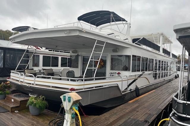 2008 Fantasy houseboat docked, featuring spacious deck and modern design.