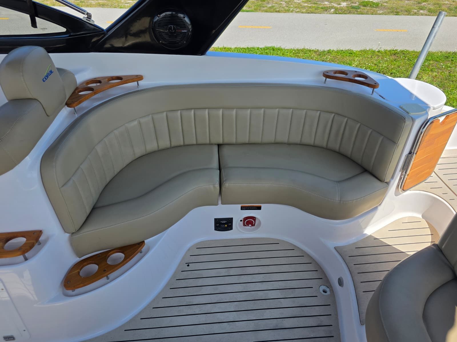 The image shows an elegant seating area on a boat with gray upholstery and wood accents.