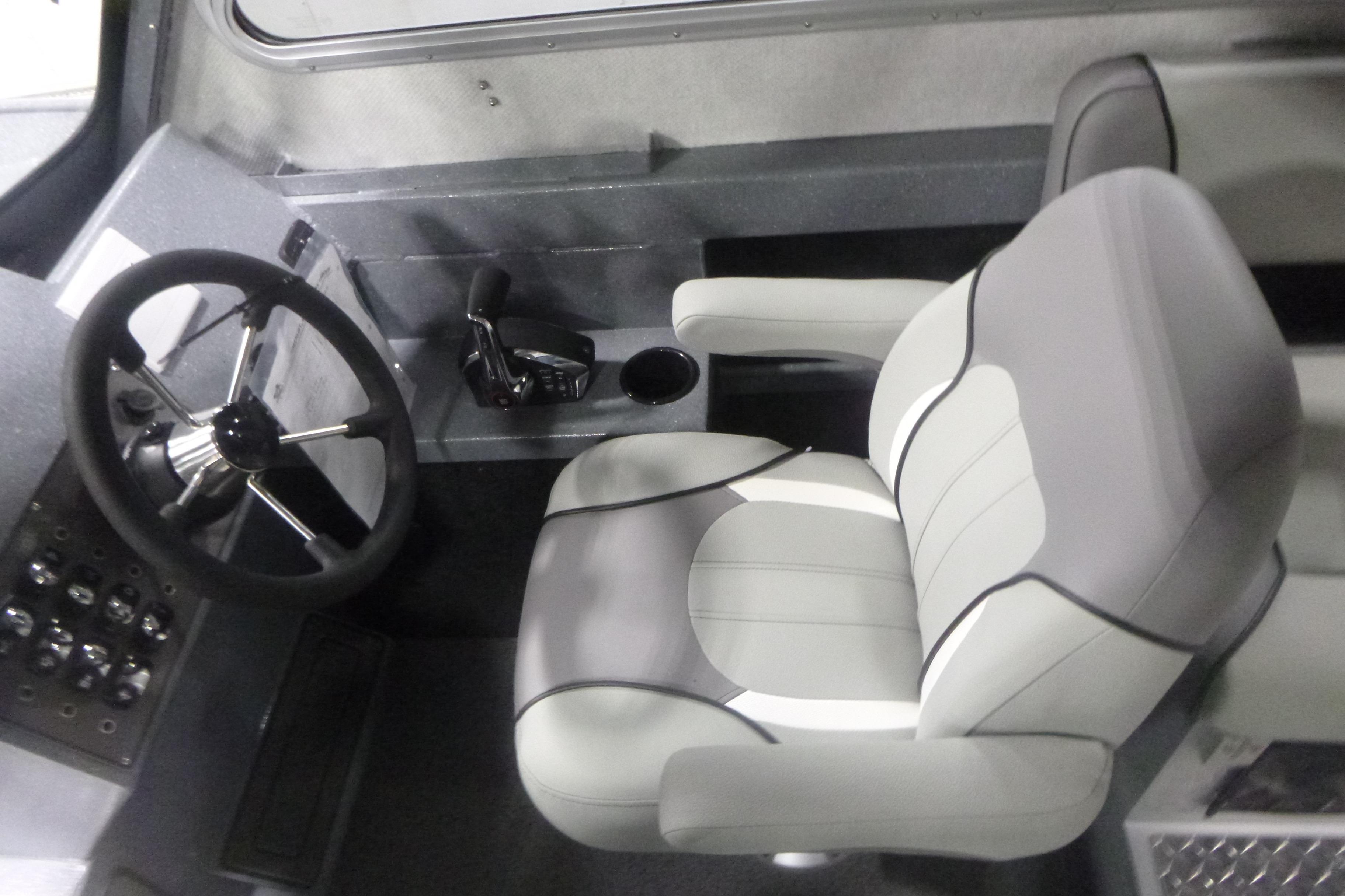 Interior of 2026 KingFisher 2425 Escape HT boat, featuring steering wheel and captain's chair.