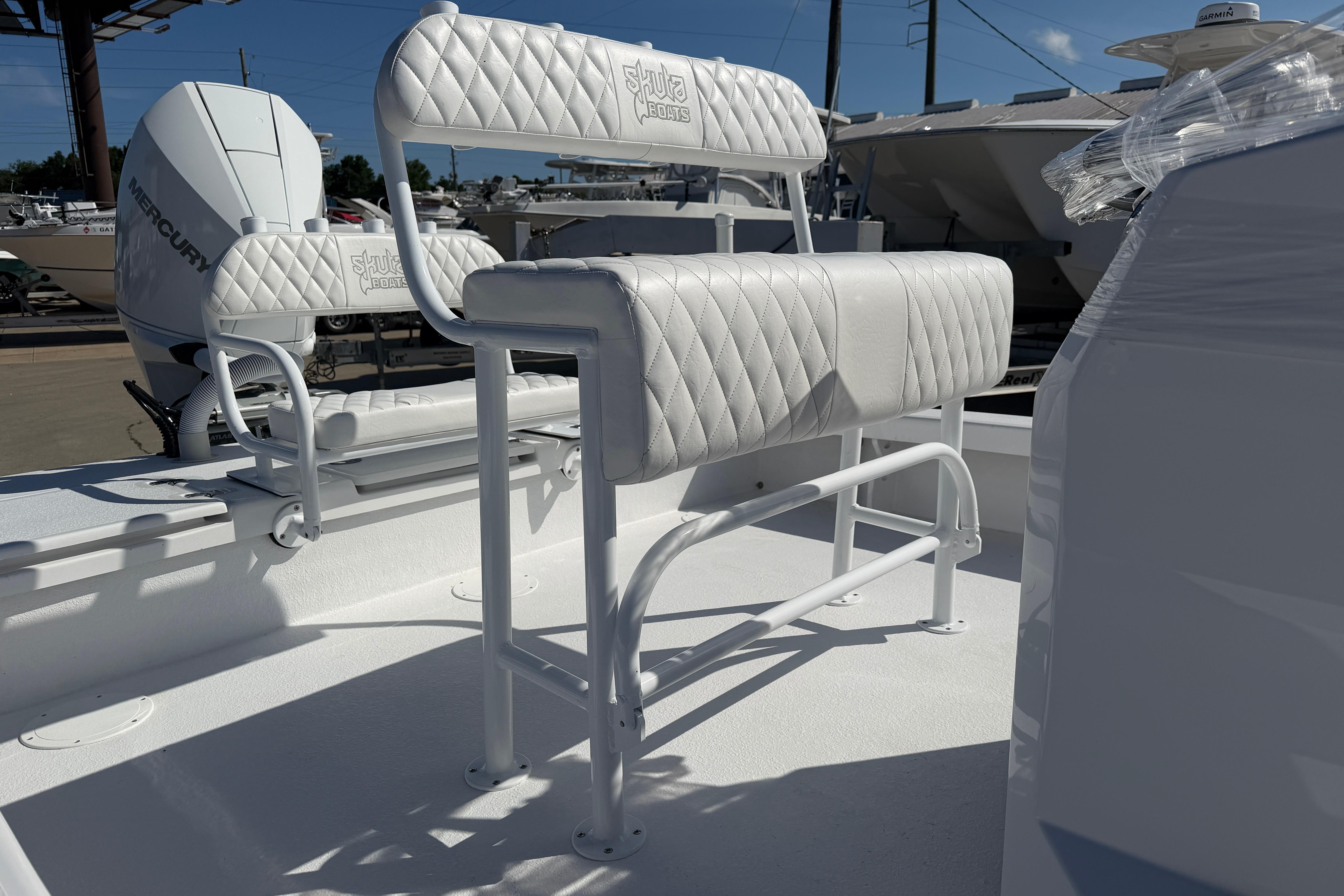 2026 Skuta 24 Cat boat with white quilted seating and Mercury engine.