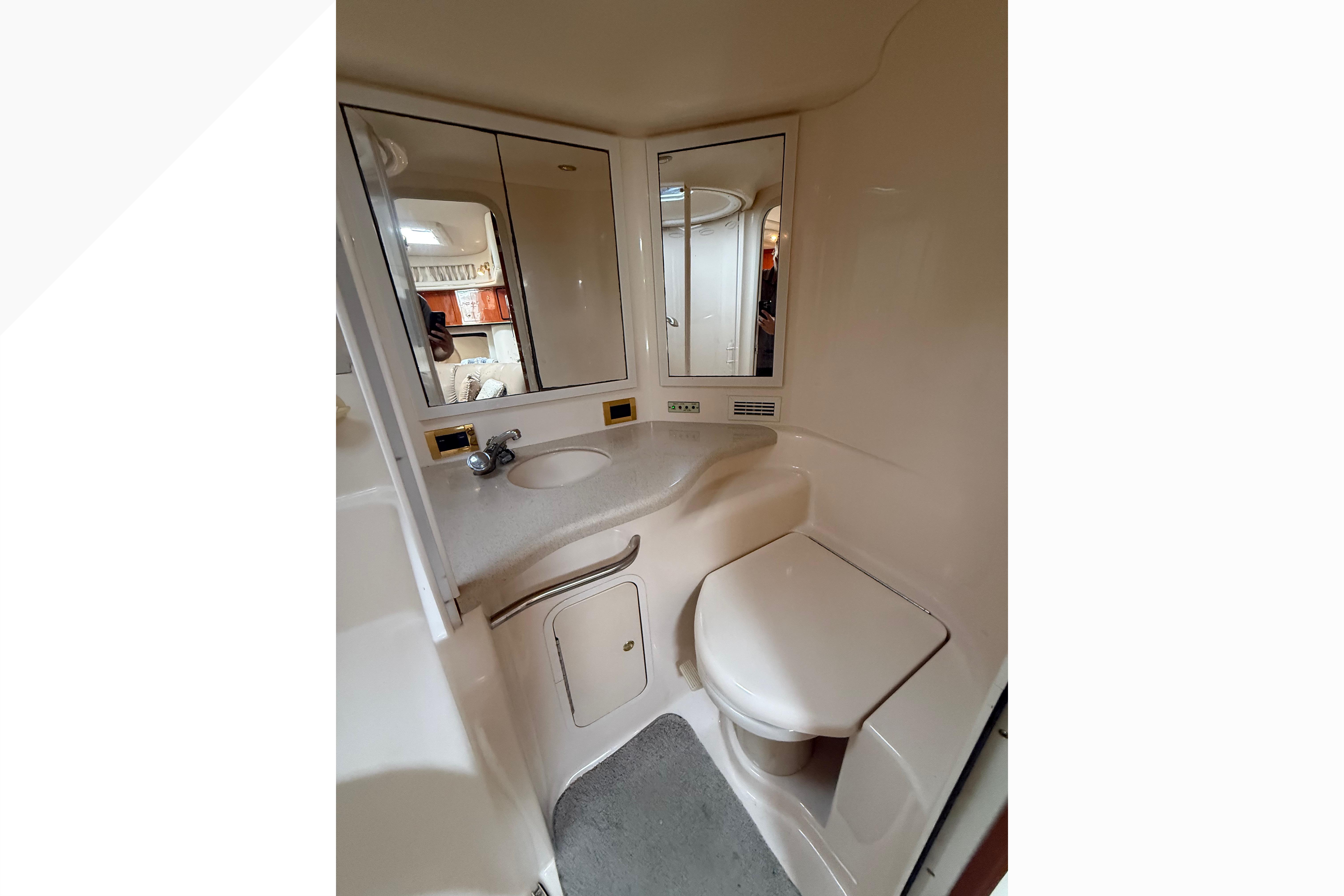 1998 Sea Ray Sundancer 400 bathroom with sink, mirror, and toilet.