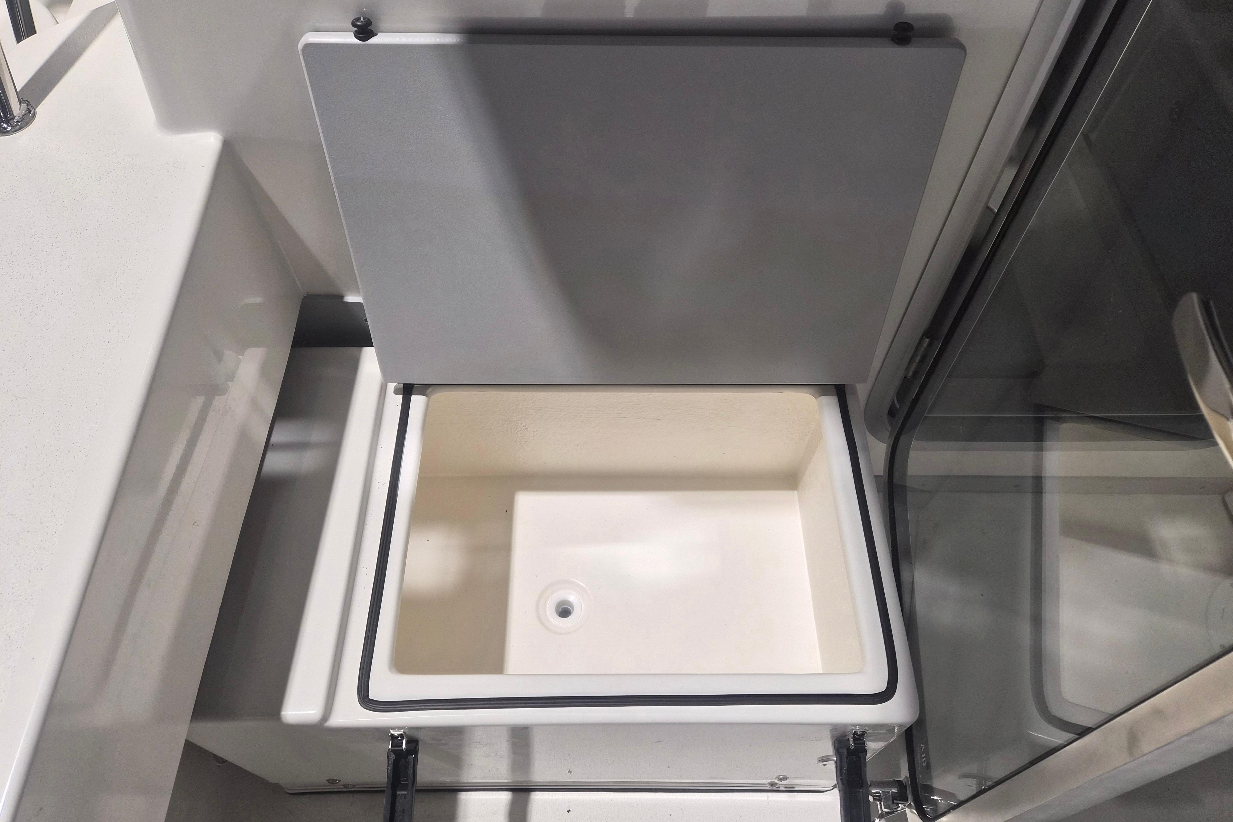 Storage compartment on 2026 Defiance Admiral 260 EX boat, open lid view.