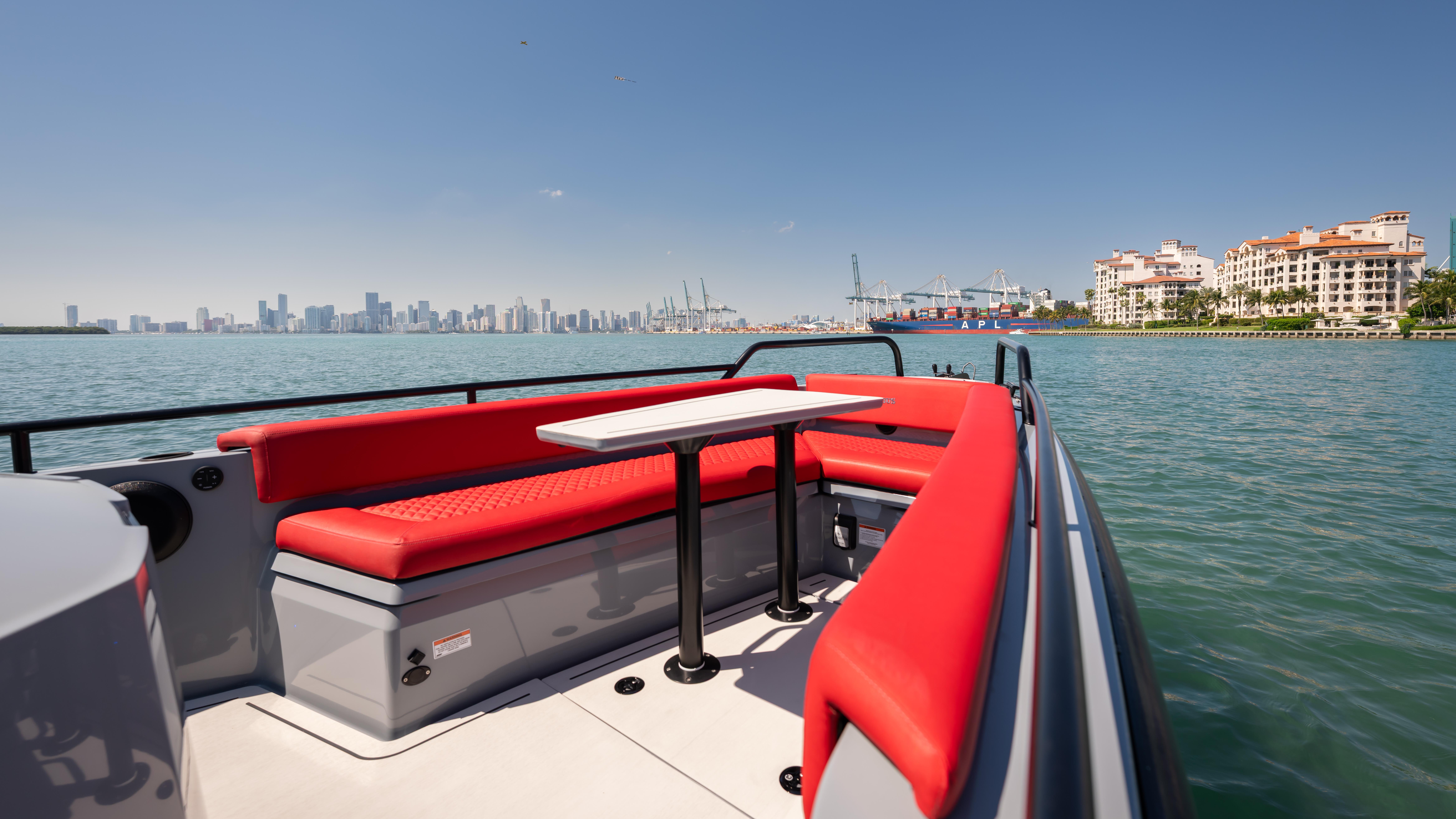 2023 BRABUS Shadow 500 T-Top boat with red seating, city skyline in background.