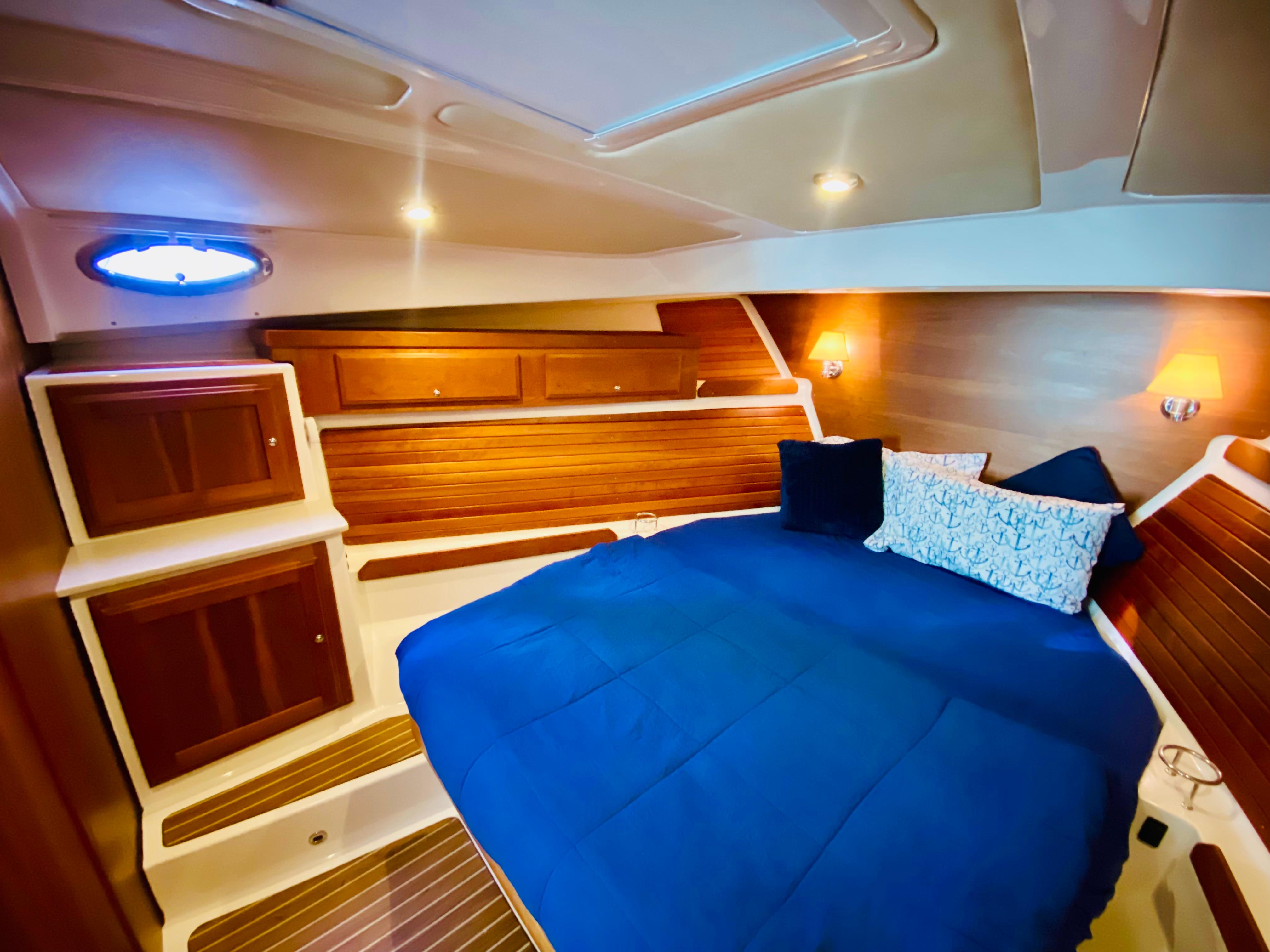 Luxurious cabin interior of 2014 Back Cove 41 yacht with blue bedding.