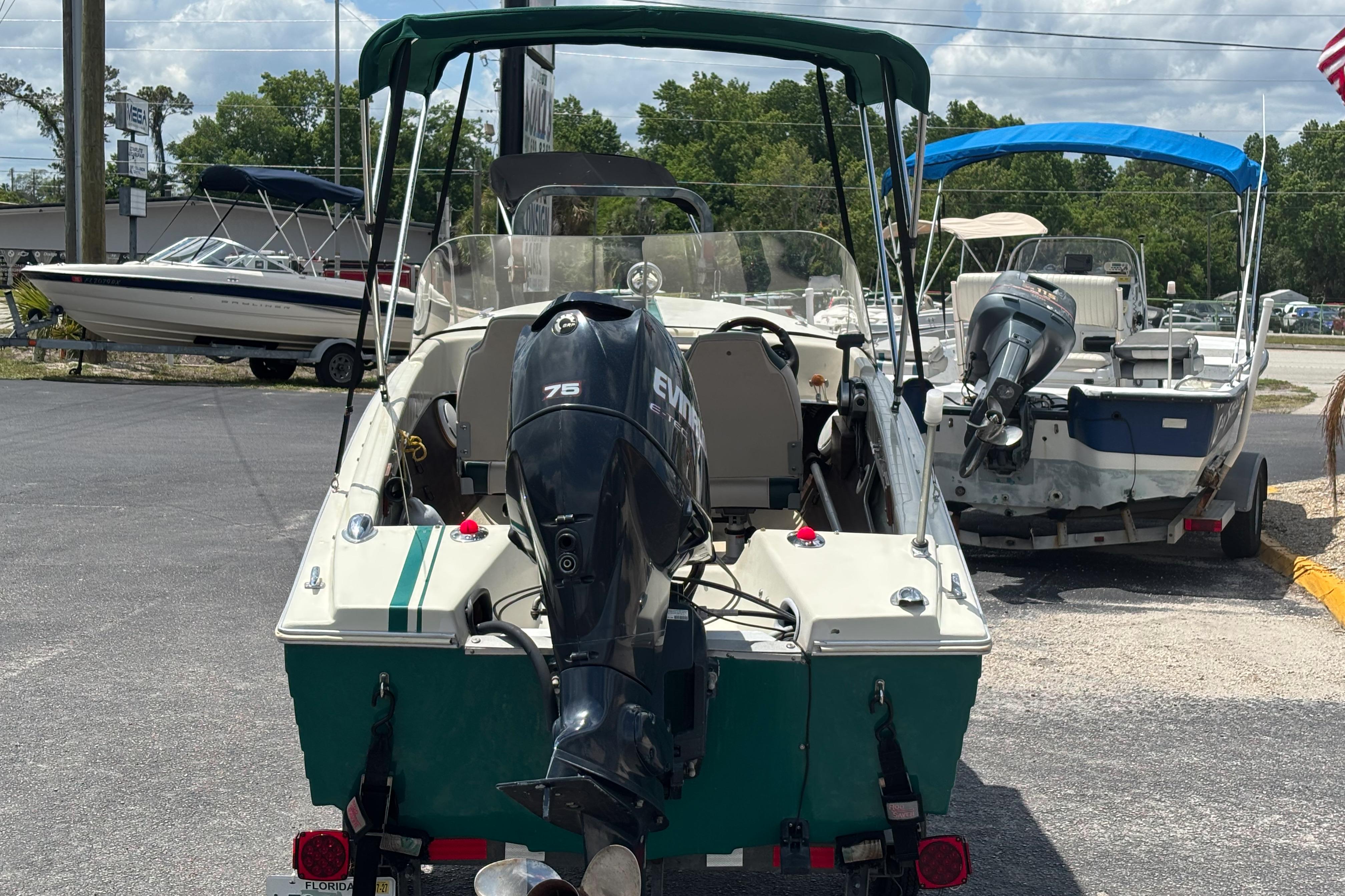 1966 Mohawk 15 boat with Evinrude 75 engine, parked outdoors on a sunny day.