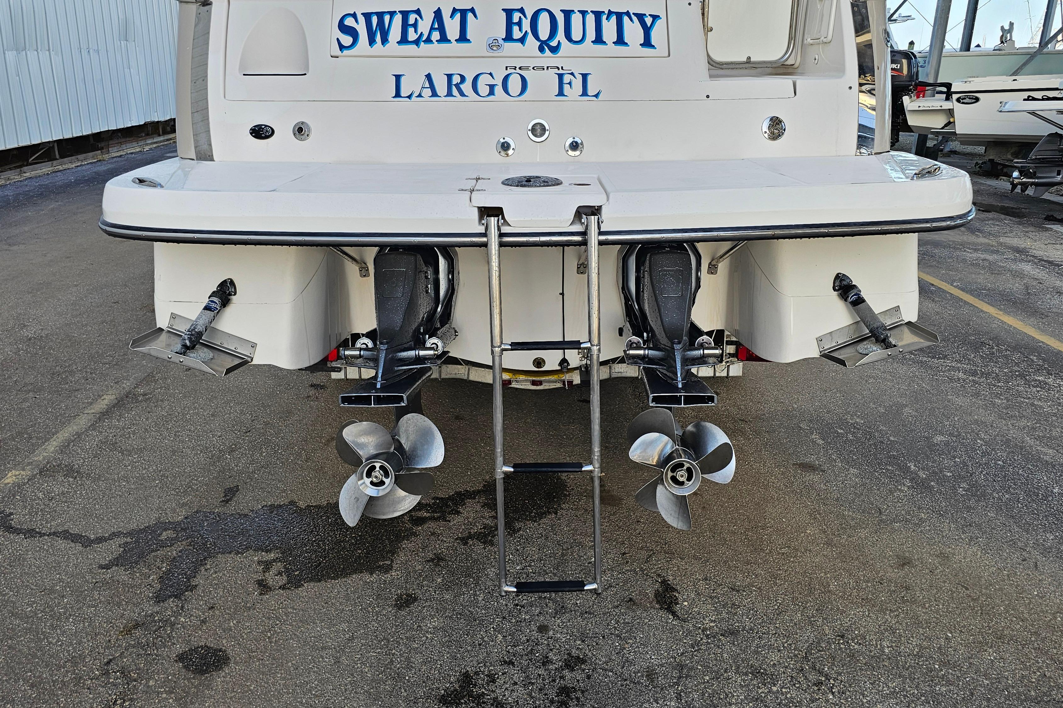 Rear view of a 2005 Regal 3060 Window Express boat with dual propellers and swim platform.