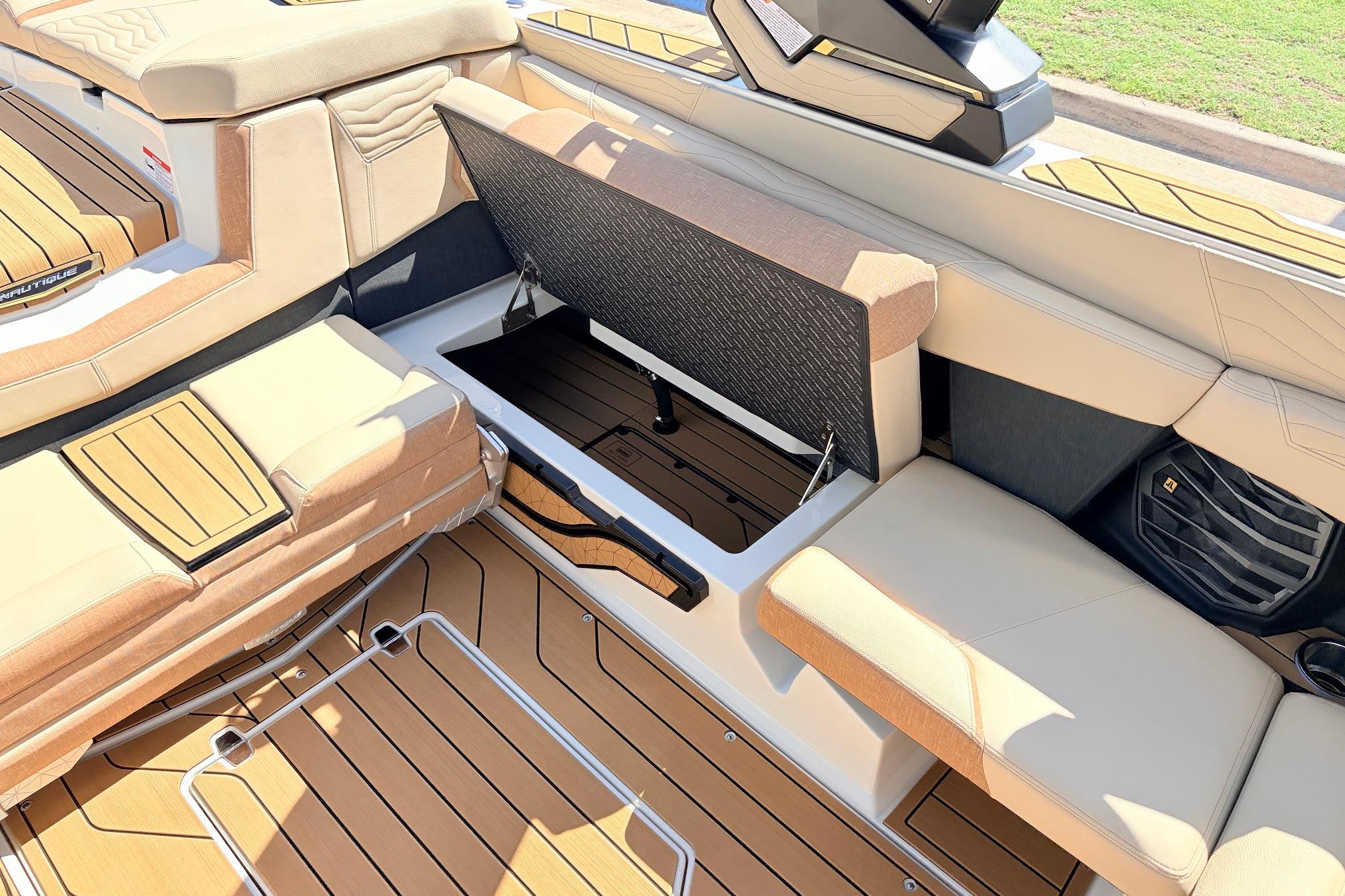 2026 Nautique Super Air Nautique G23 interior with open storage compartment and cushioned seating.