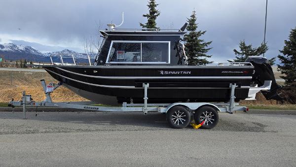 2024 Spartan 220 Maximus boat on trailer, parked with mountain backdrop.