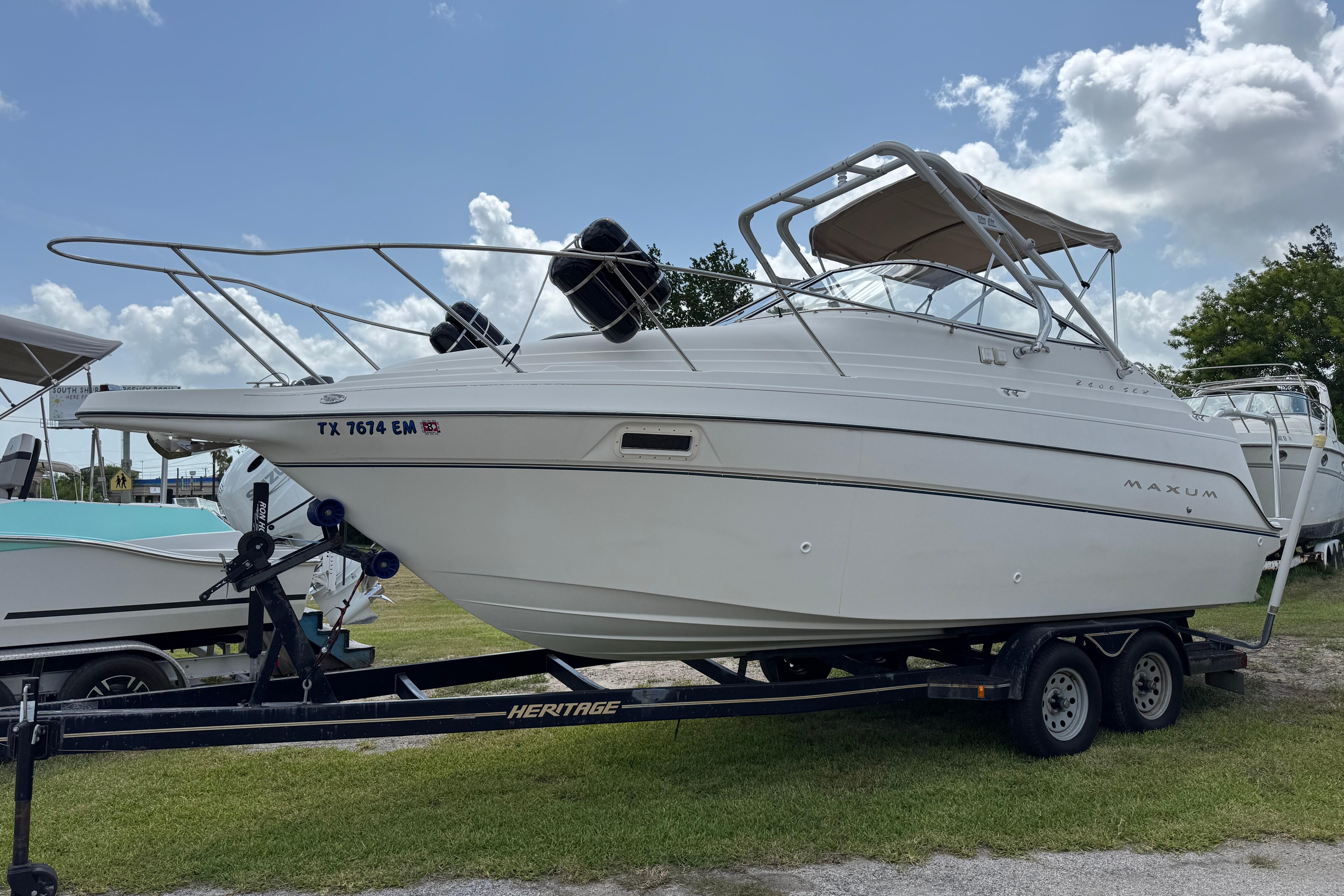 2000 Maxum 2400 SCR boat on trailer under a clear blue sky.