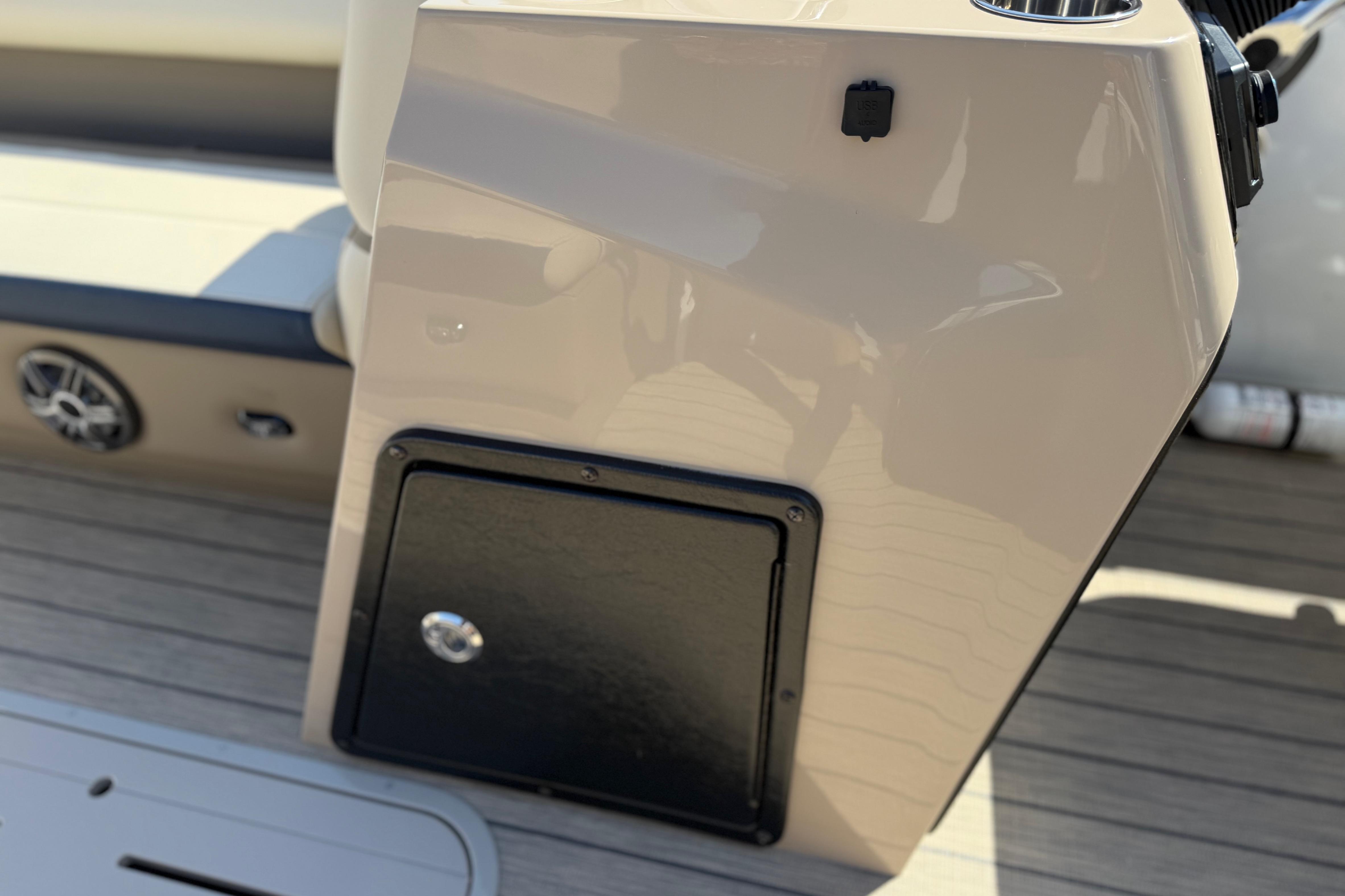 2026 SunCatcher Select 322SL boat interior detail with storage compartment and speaker.