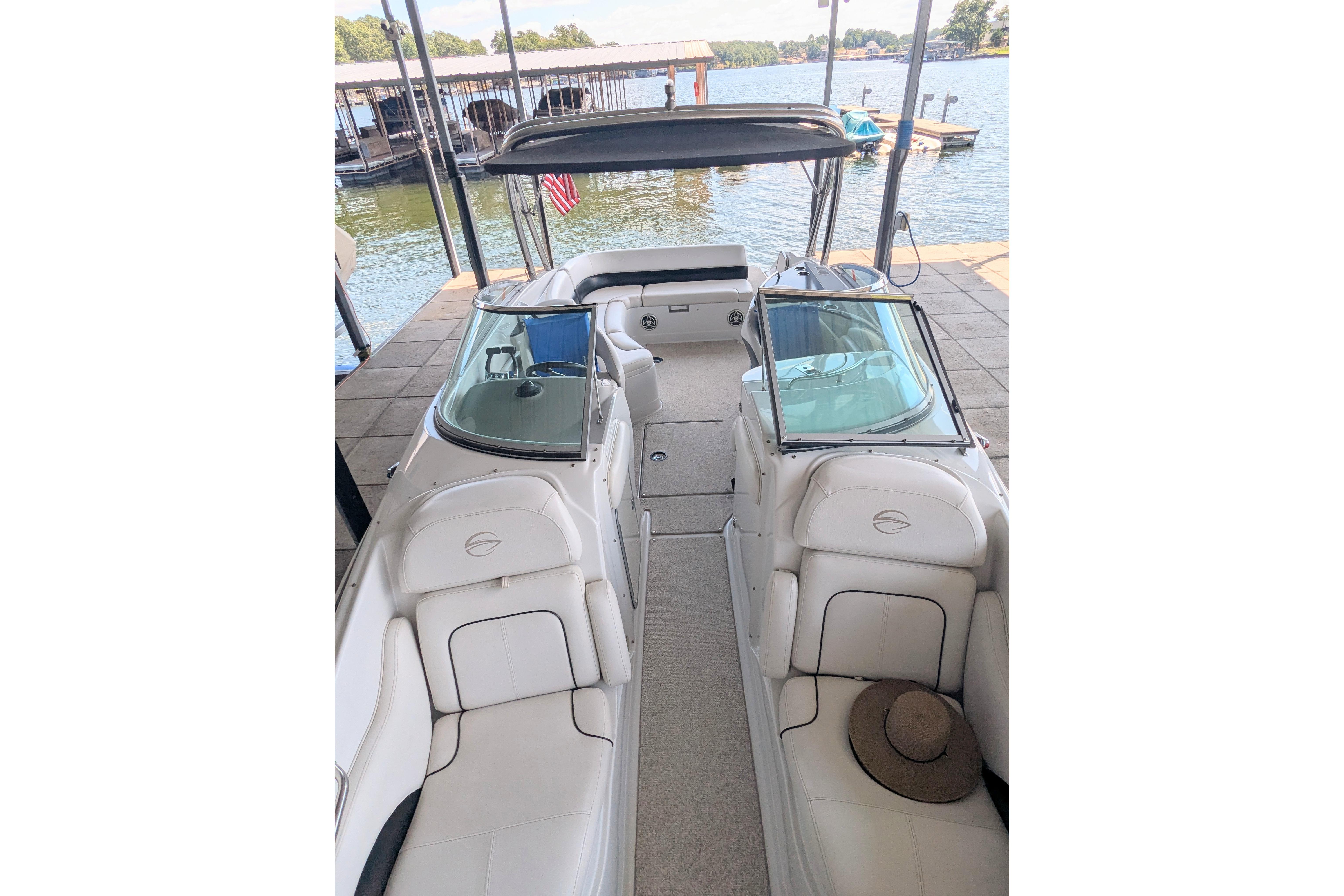 2008 Crownline 300 LS boat interior with white seating, docked by a lake.