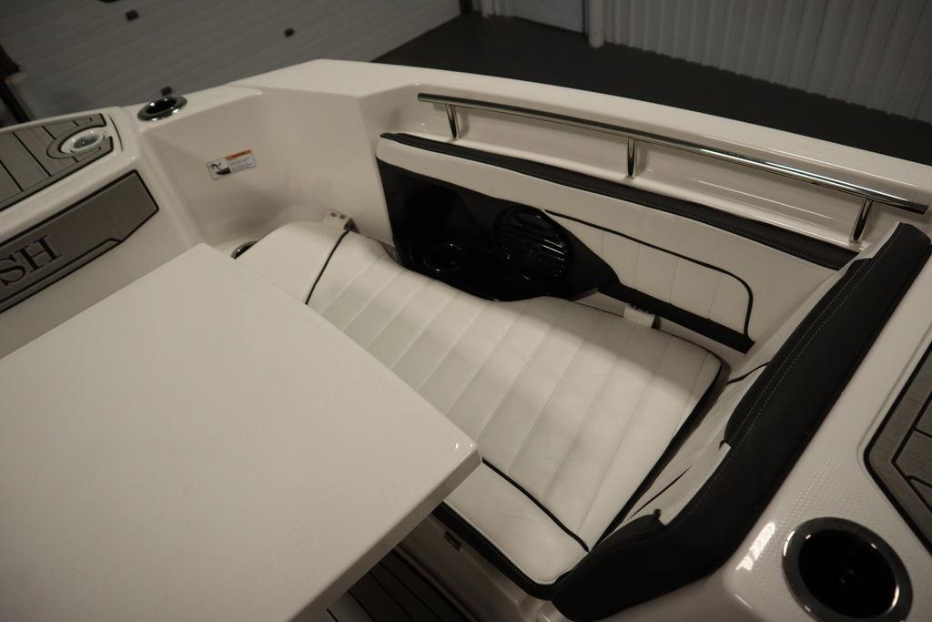 2026 Yamaha Boats 255 FSH Sport E interior with white cushioned seating and sleek design.