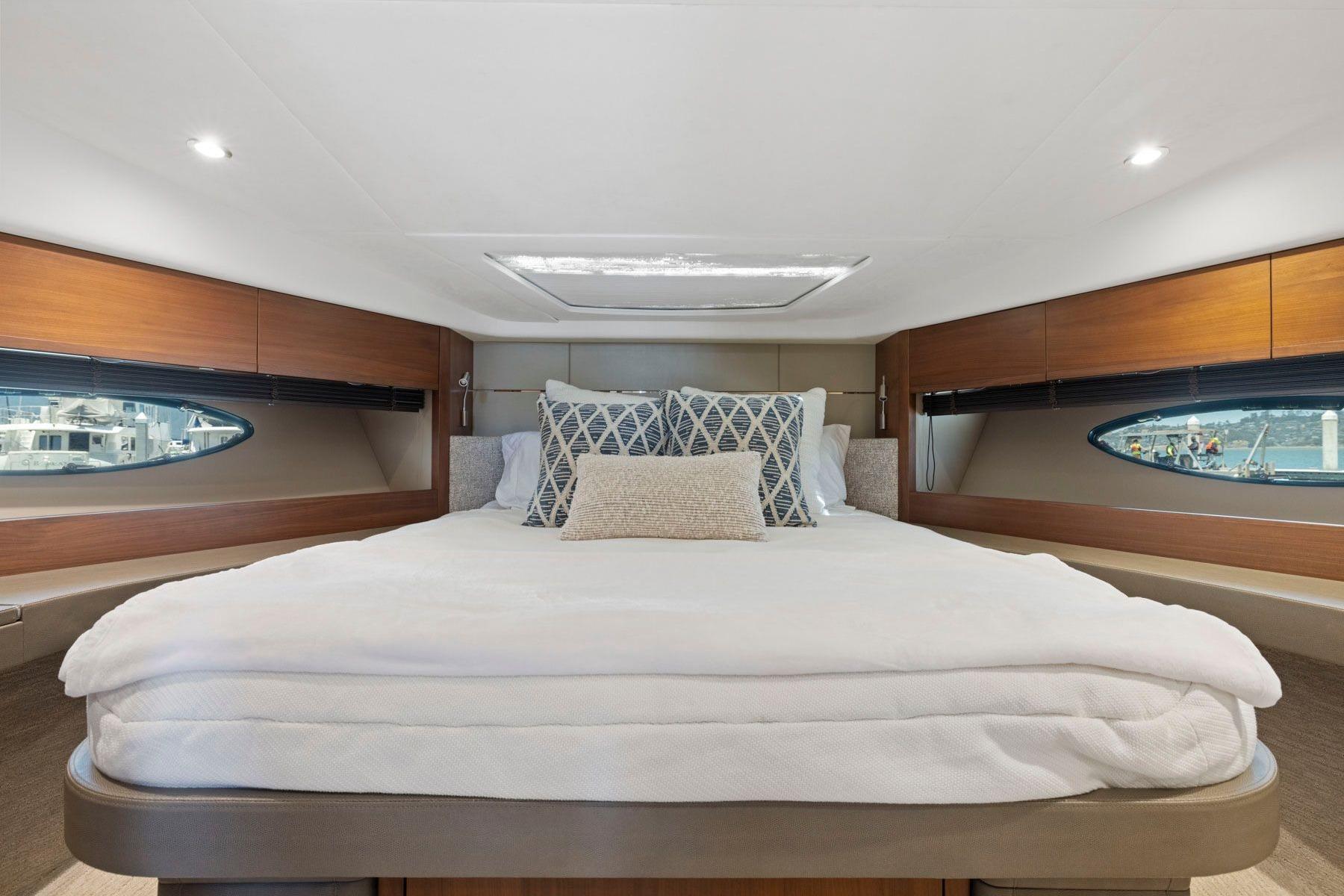 Luxurious bedroom interior of 2015 Princess 60 Flybridge Motor Yacht with elegant bedding.