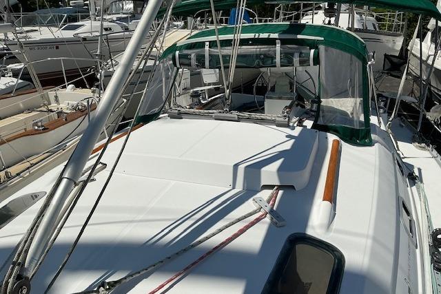 Sailboat Beneteau Oceanis 321, 2000 model, docked with green canopy and clean deck.