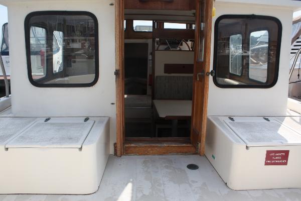 The image shows the stern of a 1985 Nordic Tug 26 boat with an open entrance.