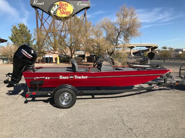 2025 Tracker Bass Tracker Classic XL boat in red, parked near Bass Pro Shops.