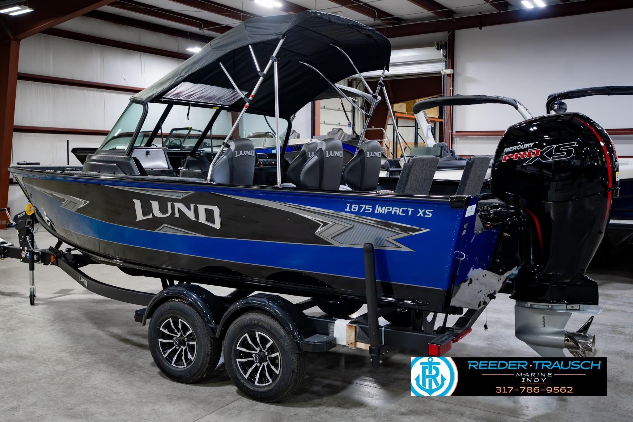 2026 Lund 1875 Impact XS boat in showroom, featuring sleek design and powerful Mercury Pro XS engine.