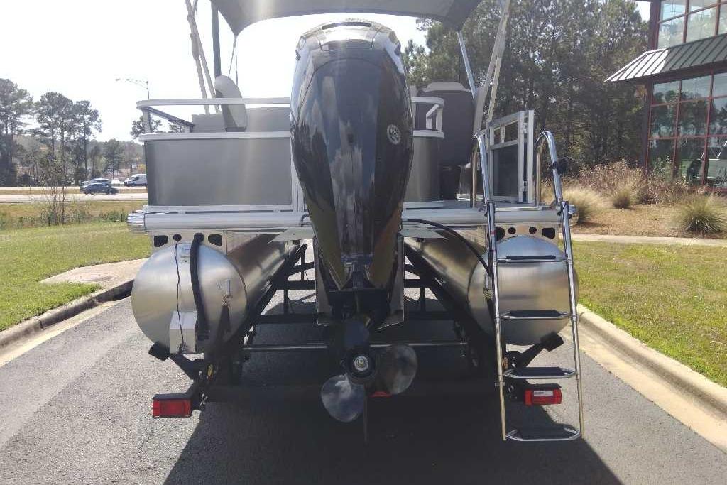 2026 Sun Tracker Bass Buggy 18 DLX pontoon boat rear view with motor and ladder.