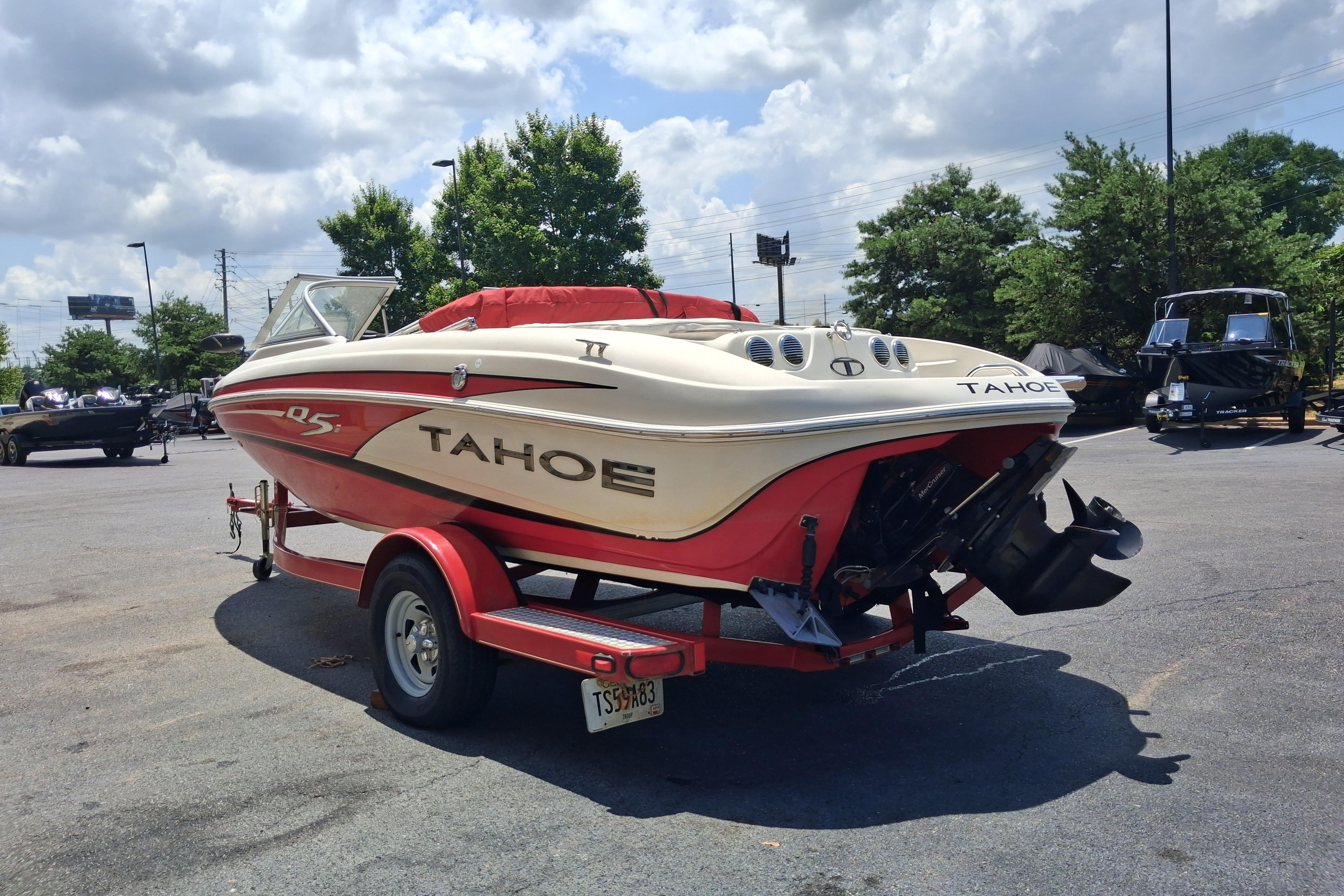 2014 Tahoe Q5i boat on trailer in parking lot under cloudy sky.