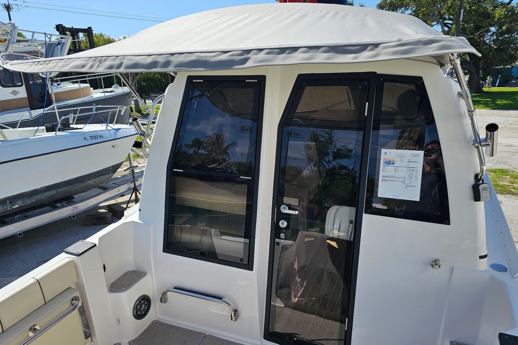 2026 Solara S-250 Coupe boat with canopy and sleek design in a marina setting.
