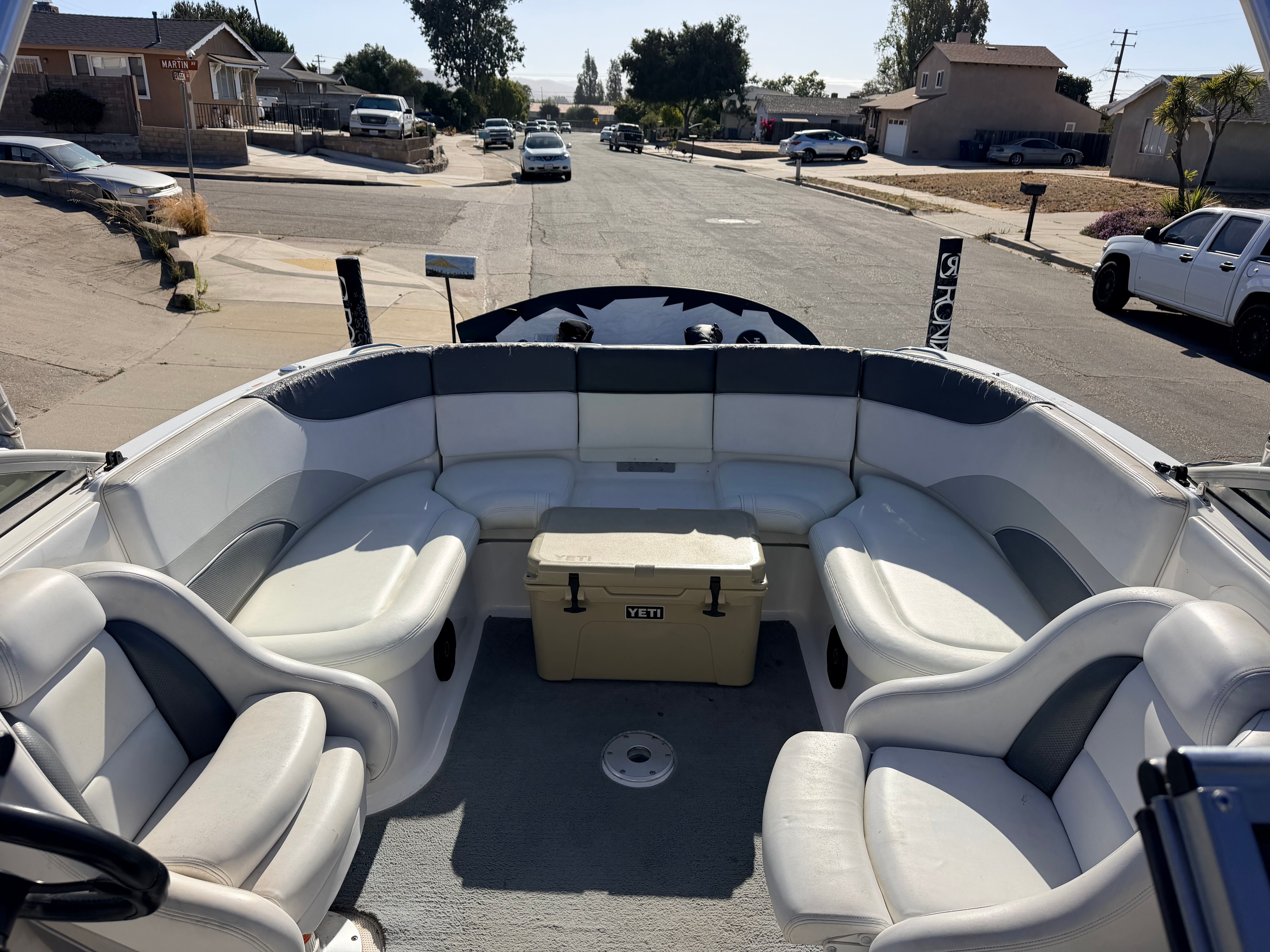 The image shows the cockpit of a 2005 Yamaha AR230 boat with white and gray seating.