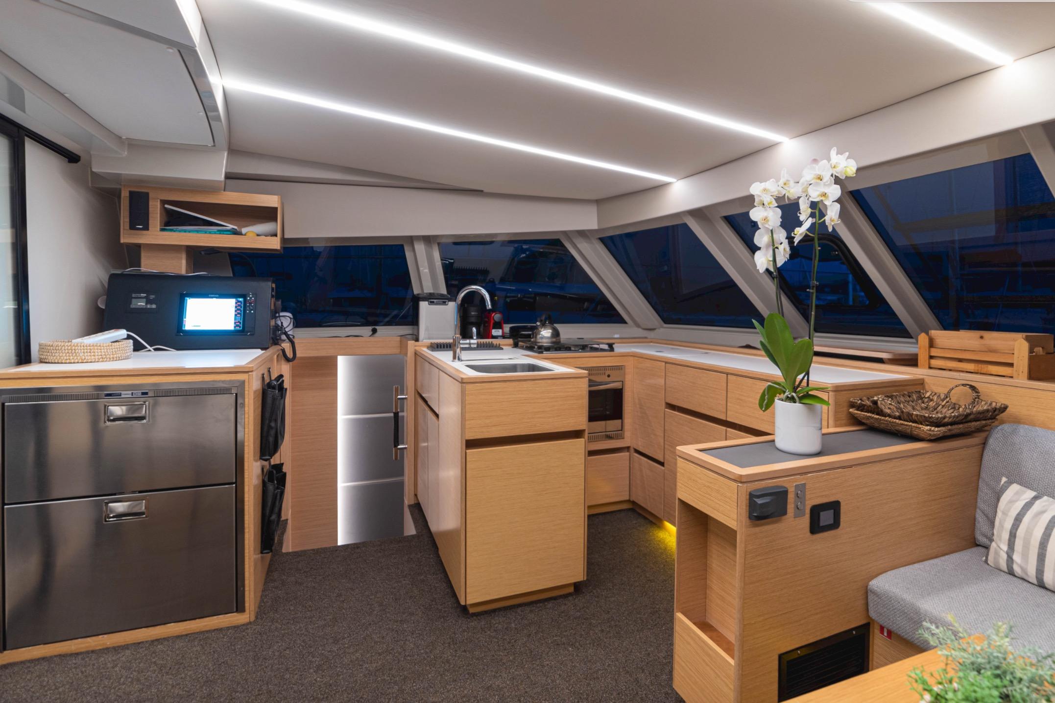 Luxurious interior of 2019 Bavaria Nautitech 47 yacht with modern kitchen and elegant decor.