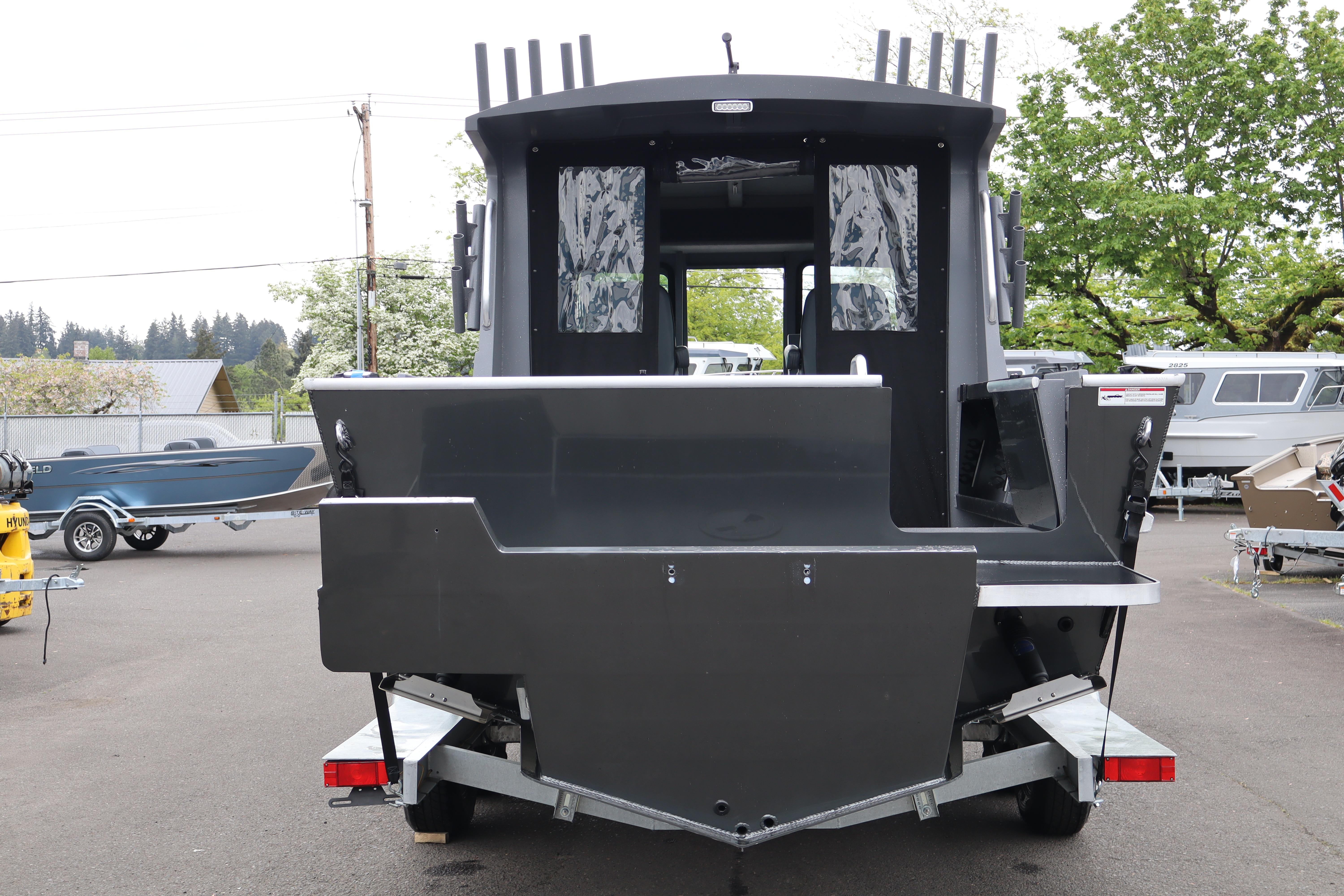 2026 Alumaweld Horizon 24 boat, rear view, parked on trailer in outdoor setting.