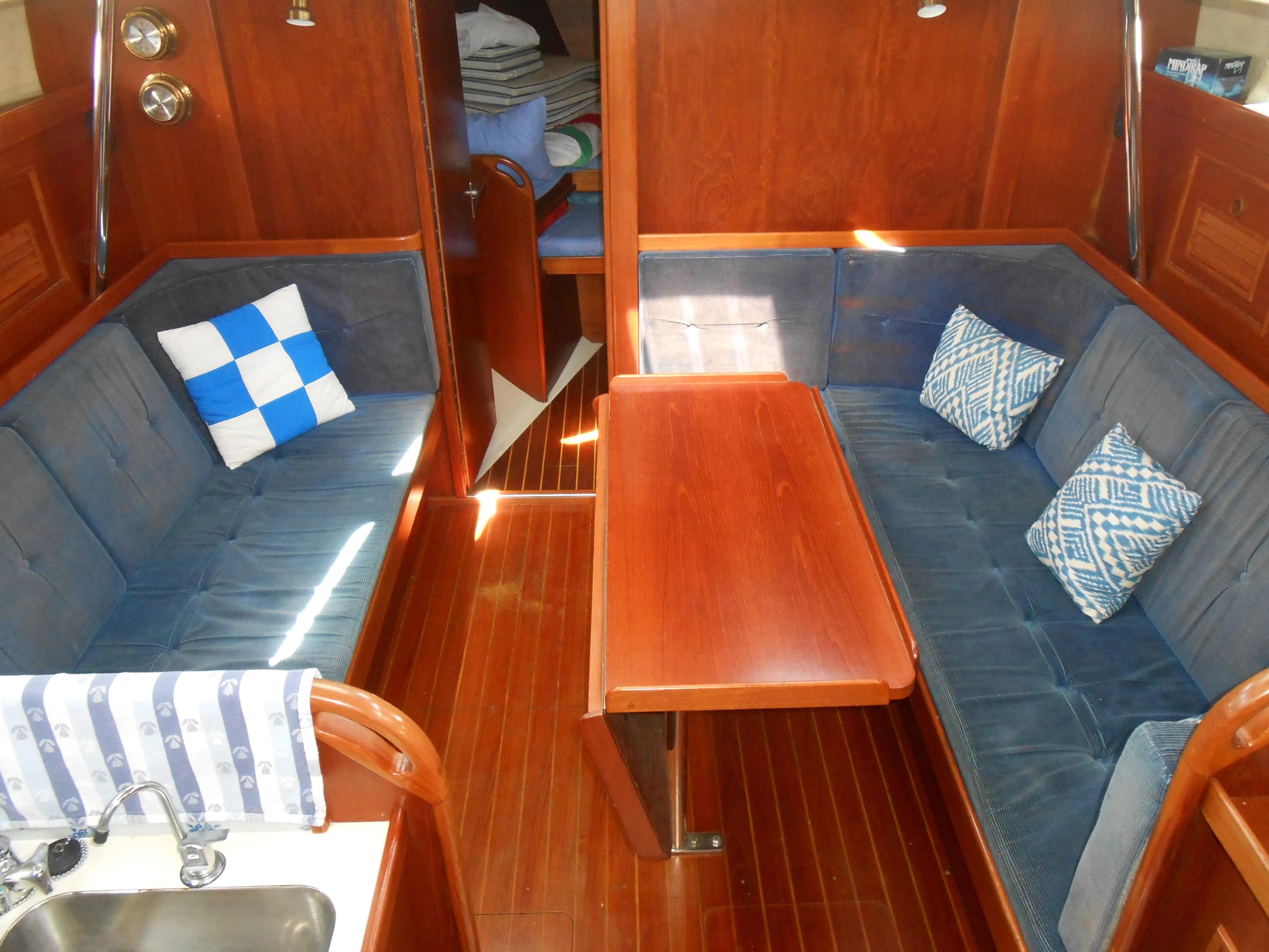 Interior of a 1985 Contest 41 Ketch with wooden furnishings and blue upholstery.