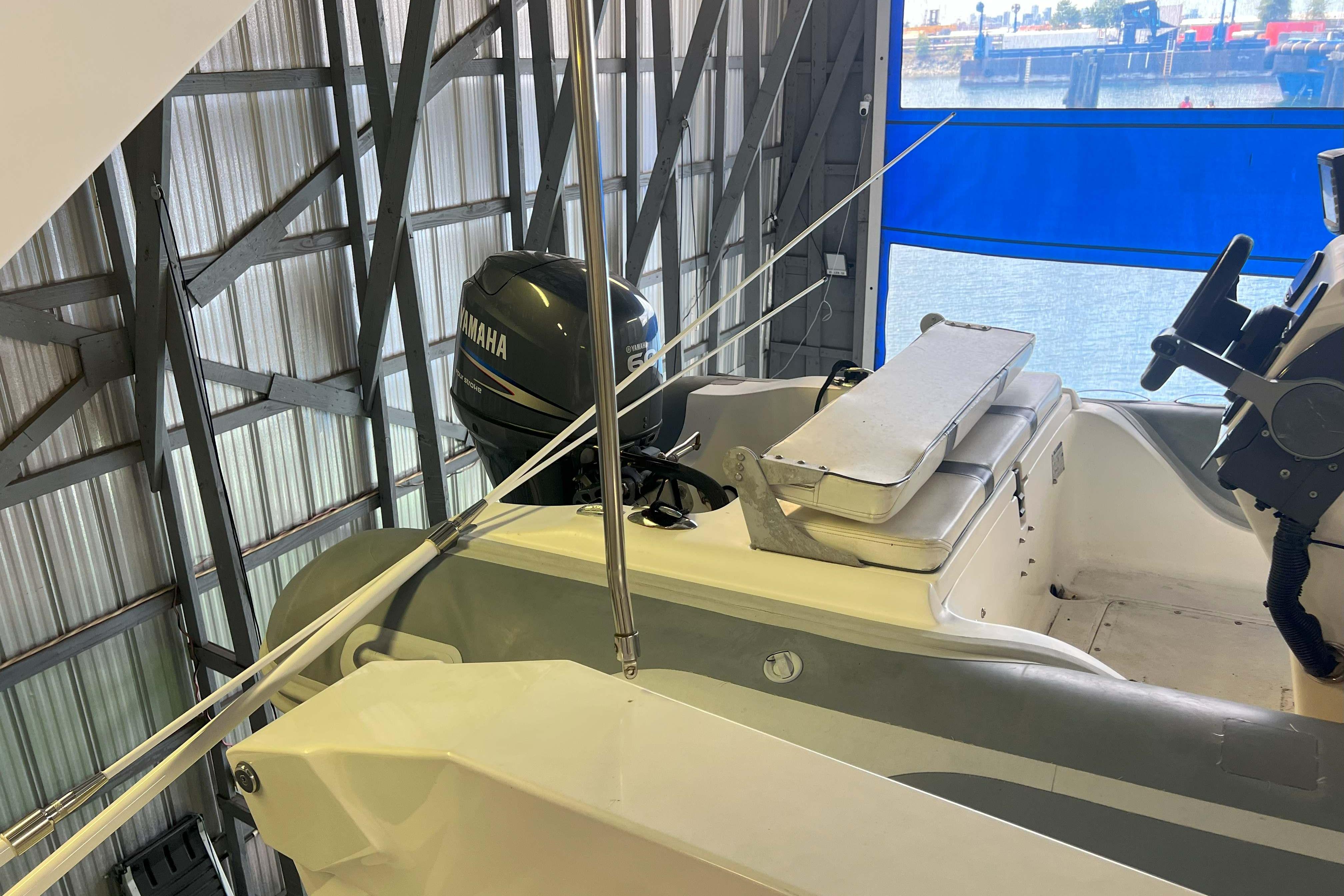 1998 West Bay 58 boat with Yamaha engine in a covered dock.