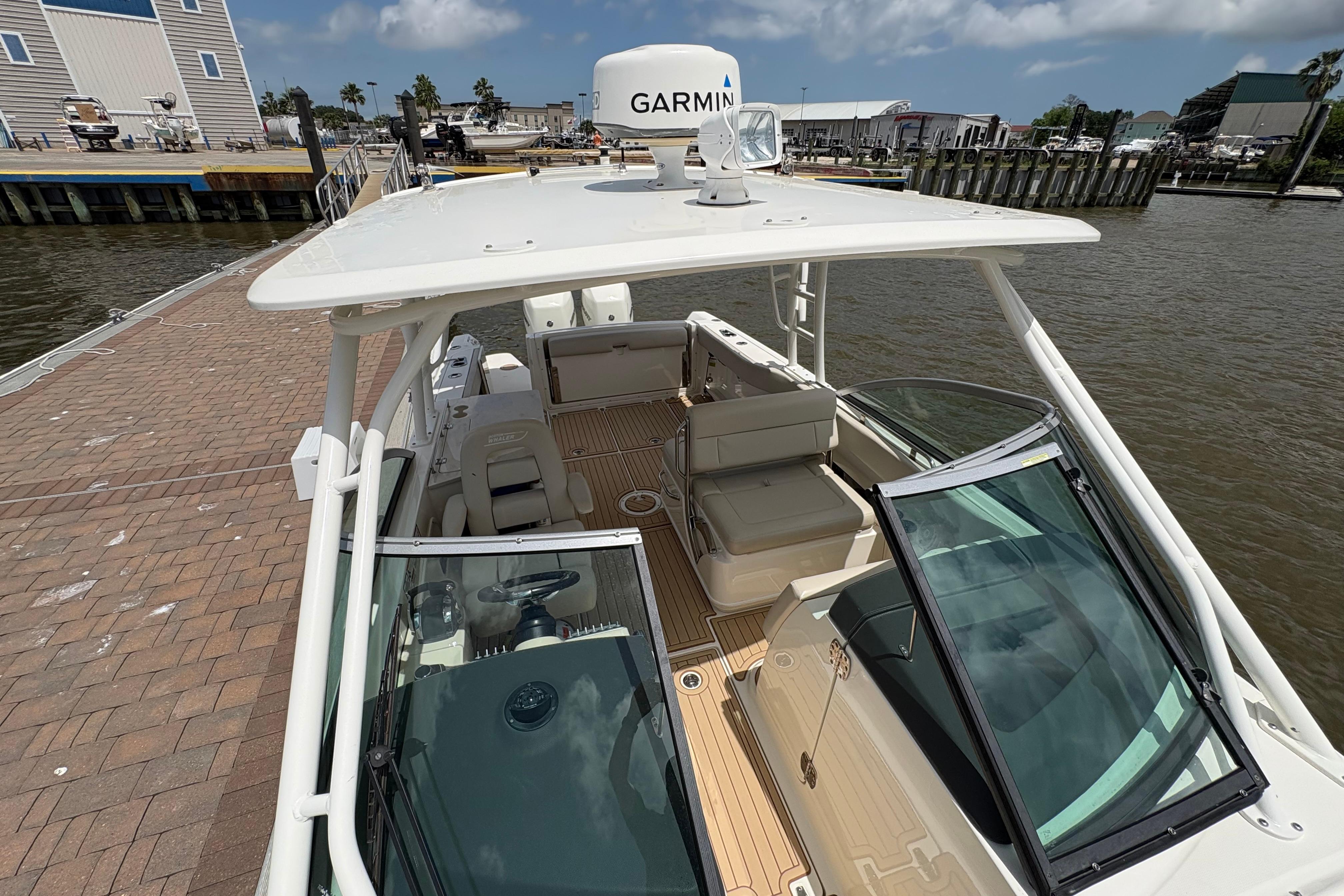2017 Boston Whaler 270 Vantage boat docked, featuring Garmin equipment and spacious seating.