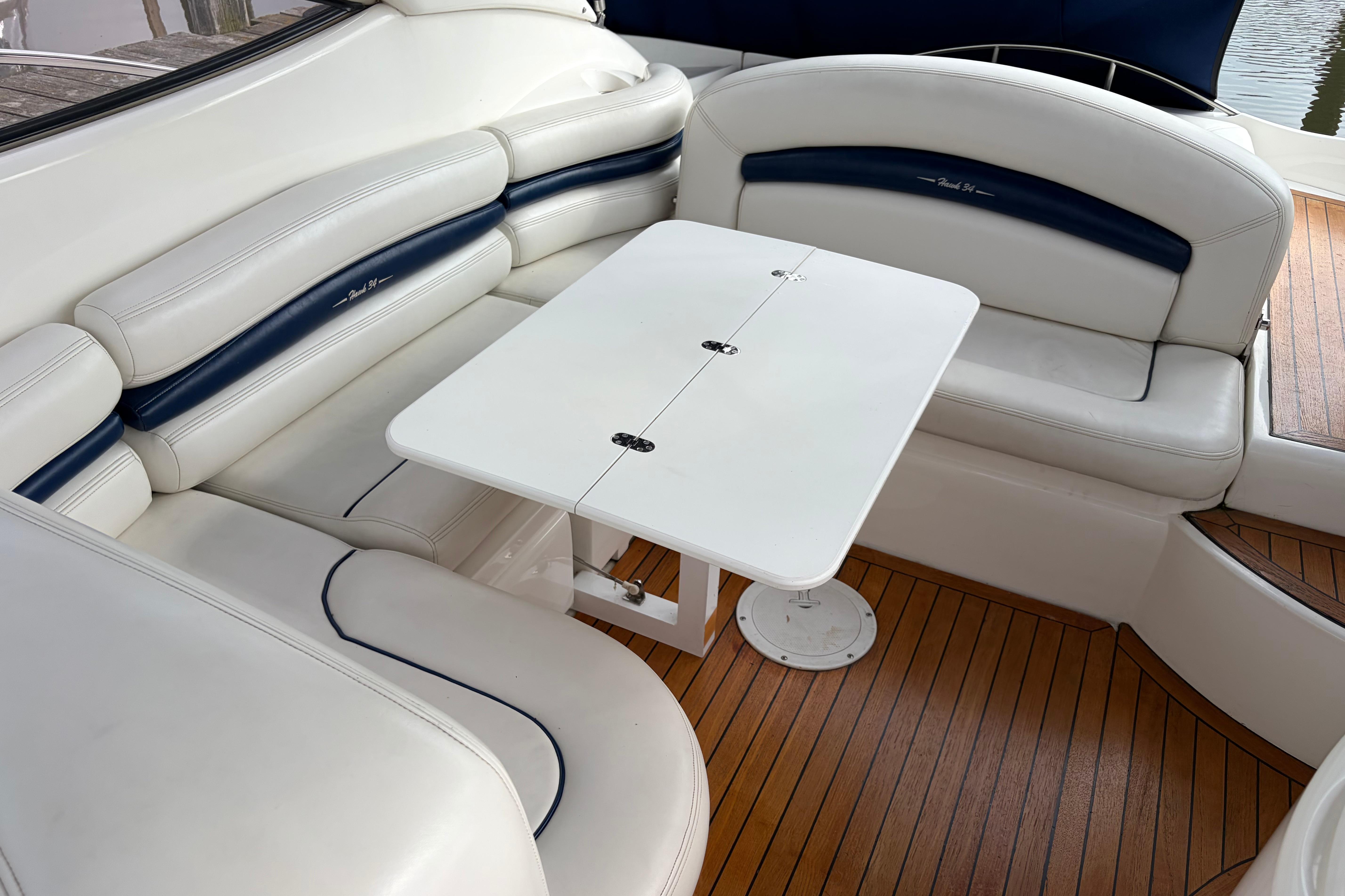 Luxurious seating area on a 2000 Sunseeker Superhawk 34 yacht with a foldable table.